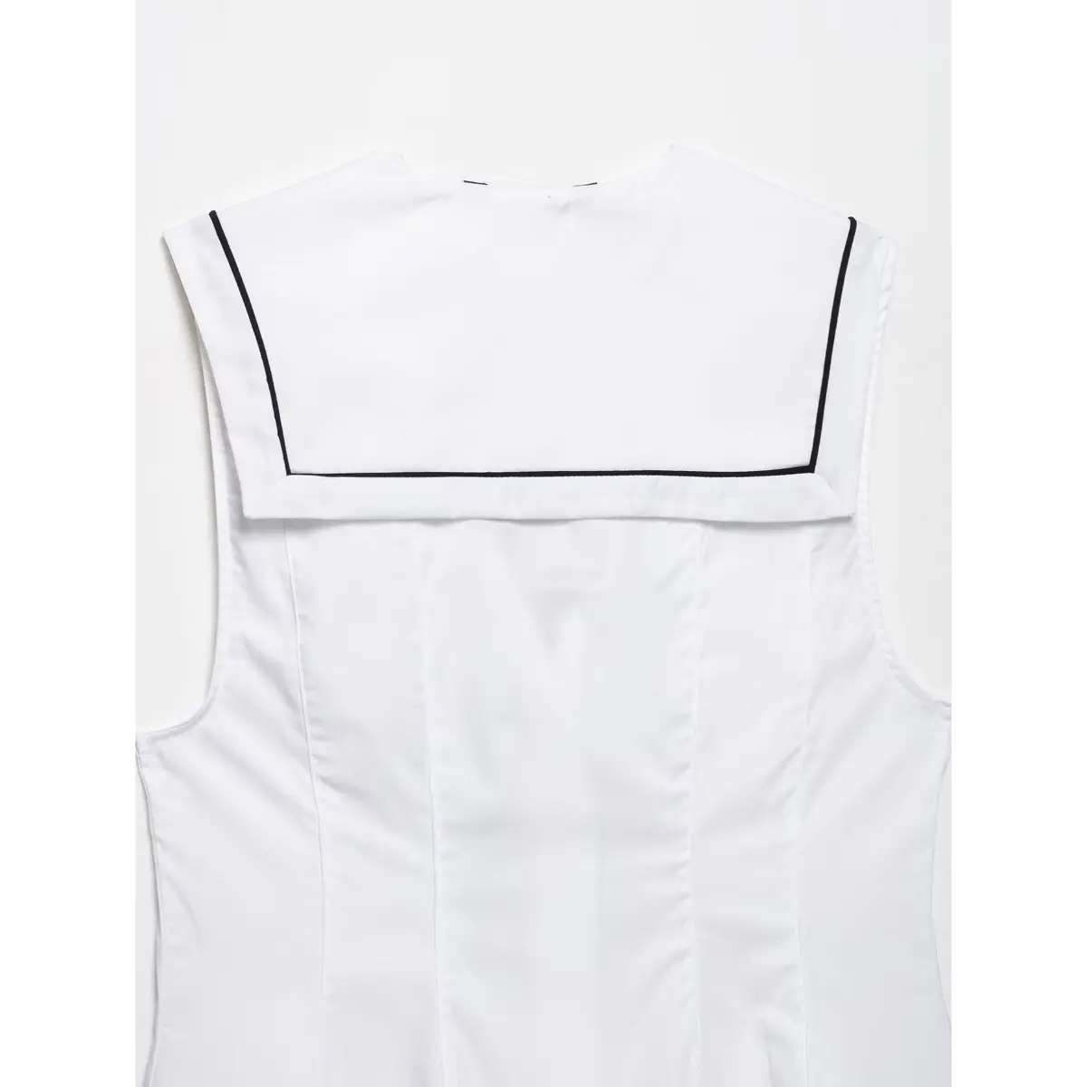 Close-up of the side seam and contrast trim on the white sleeveless top.