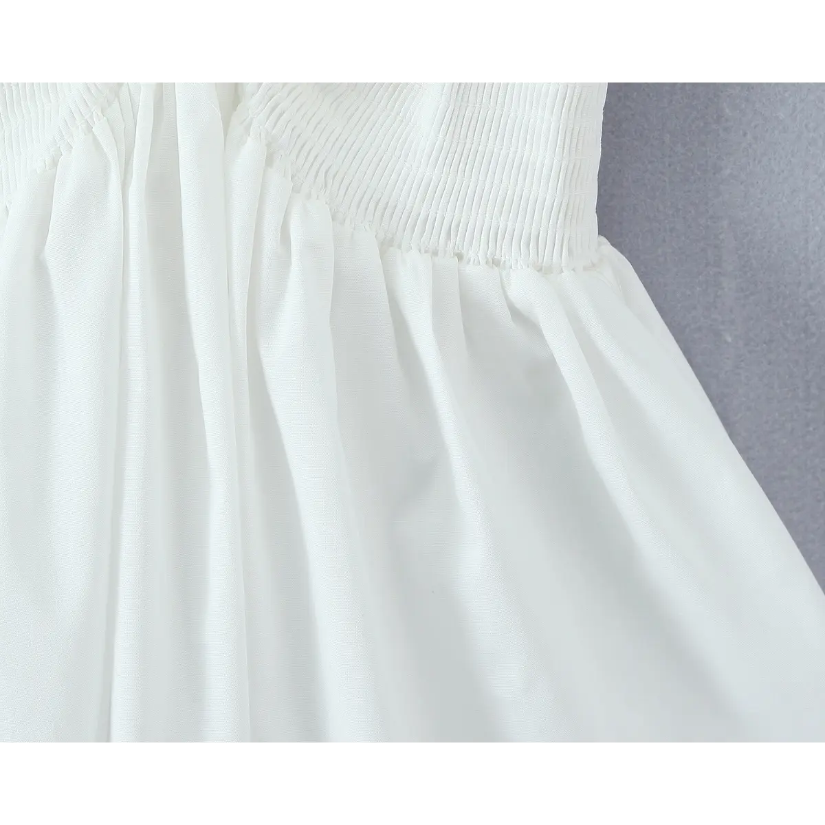 Close-up of fine smocked texture and soft woven fabric material.