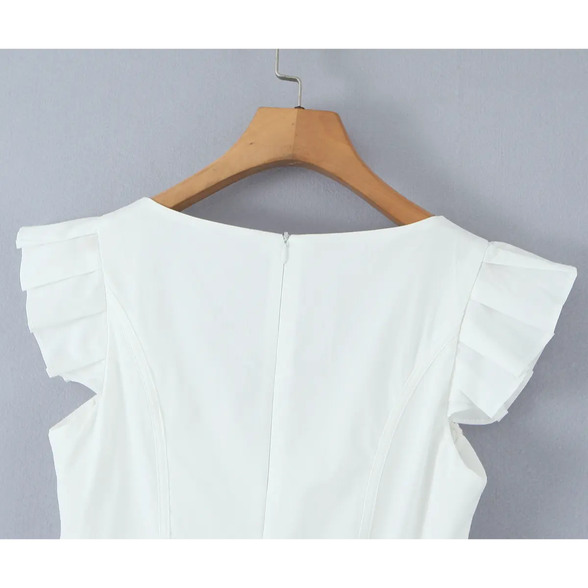 Back view of the white dress, showing the flutter sleeves and central back zipper.
