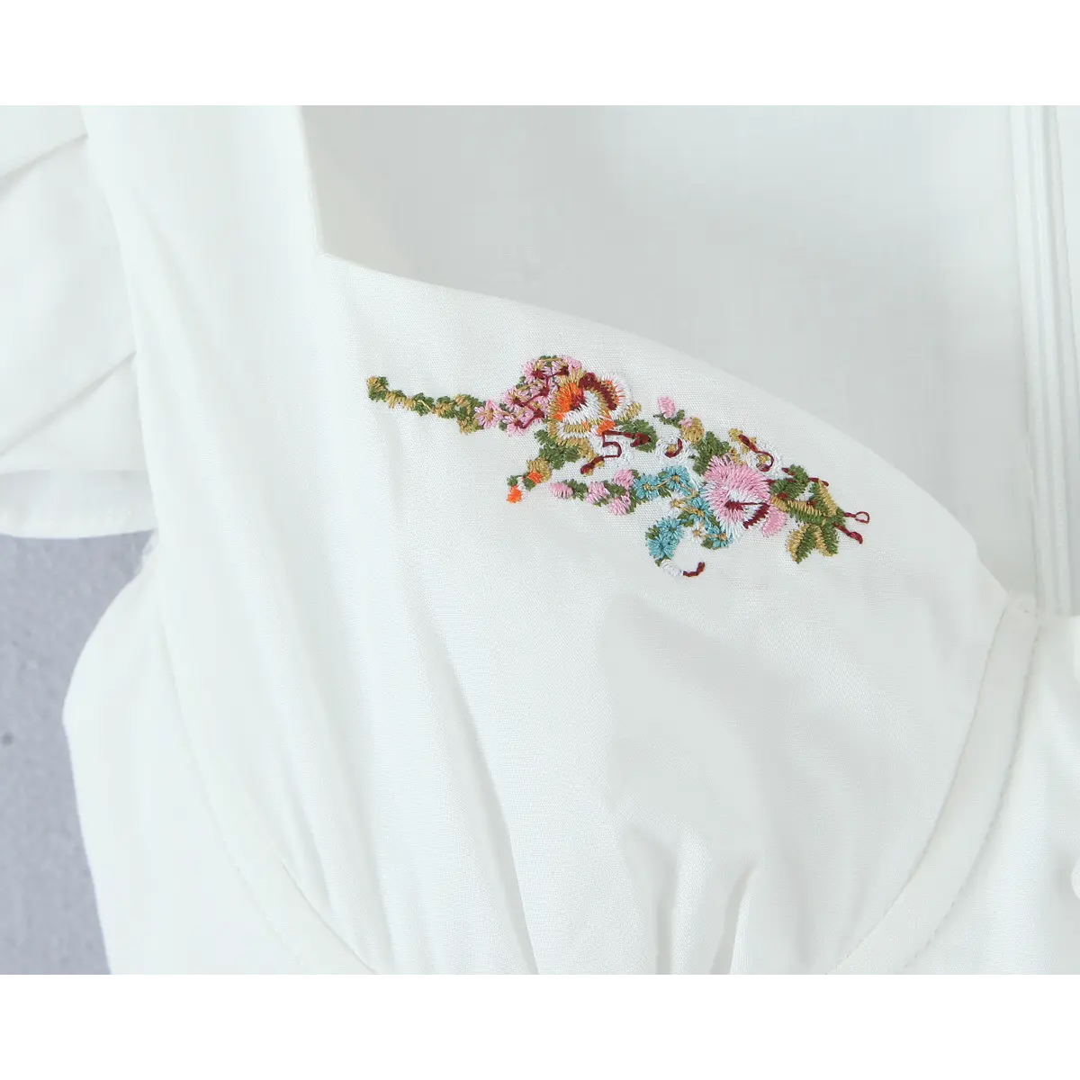 Close-up of the colorful floral embroidery on the bustier-style bodice.