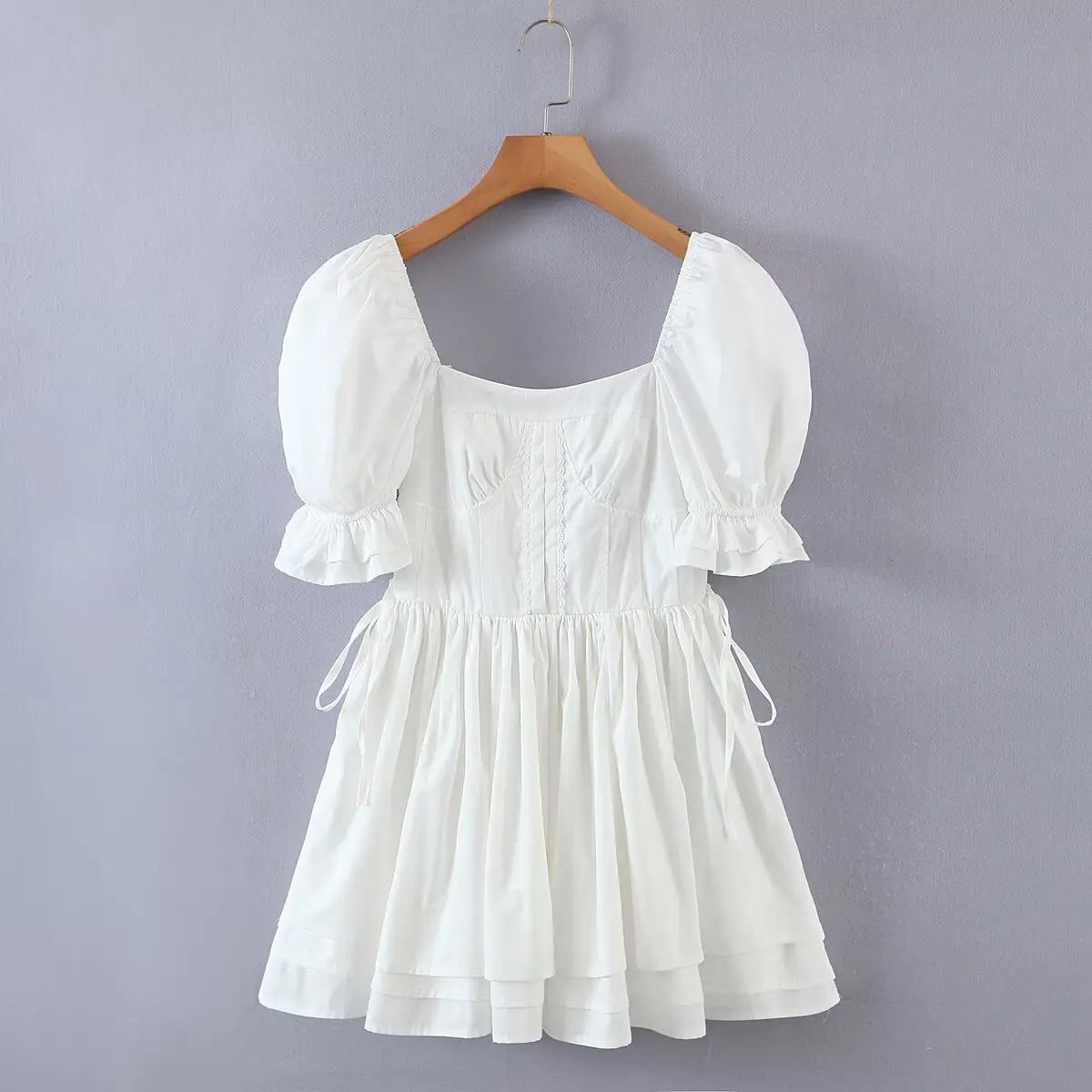 Hanging front view of the dress, showcasing the full silhouette, puff sleeves, and tiered skirt.
