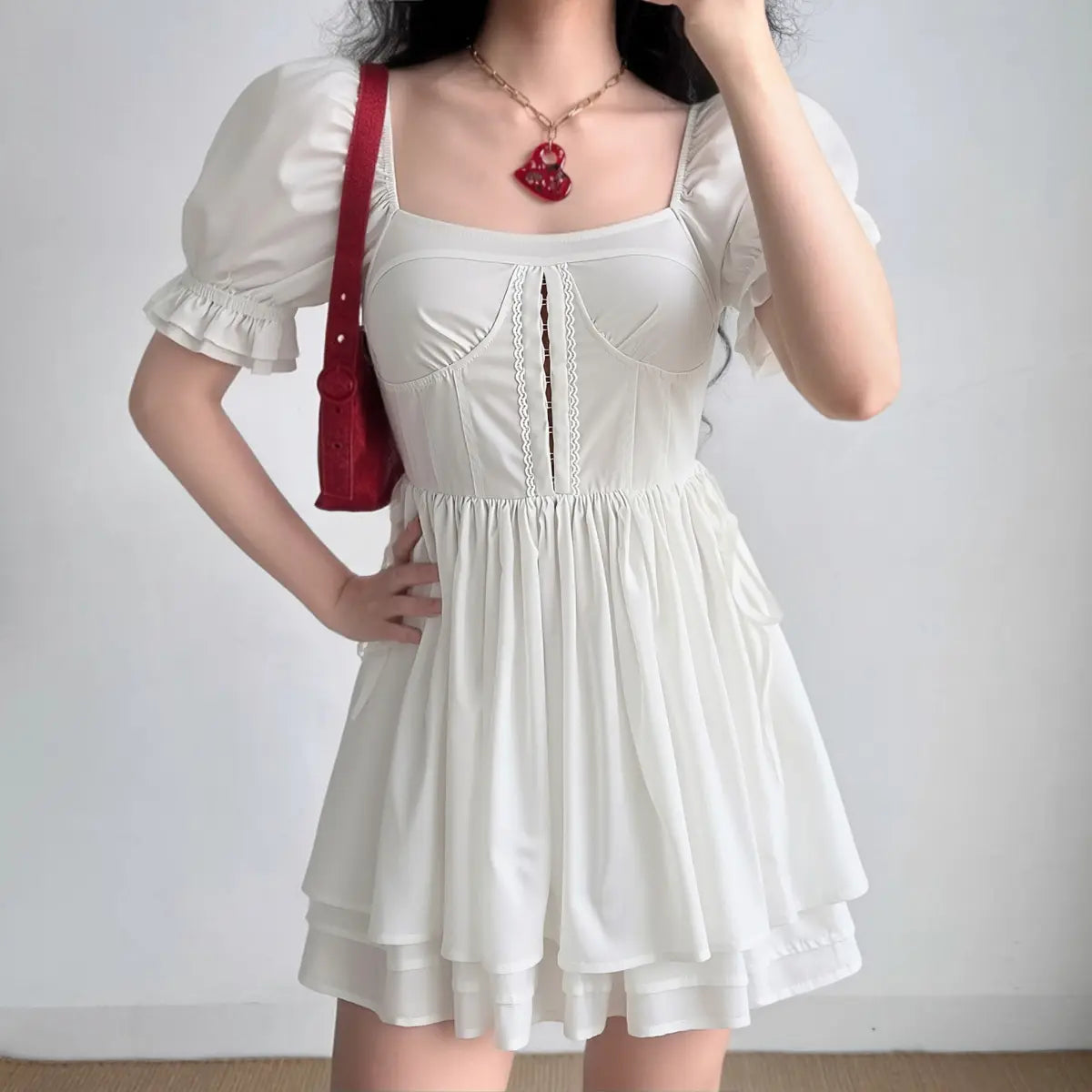  On-model view of the dress, showing the square neckline, lace-trimmed corset bodice, and tiered skirt silhouette.