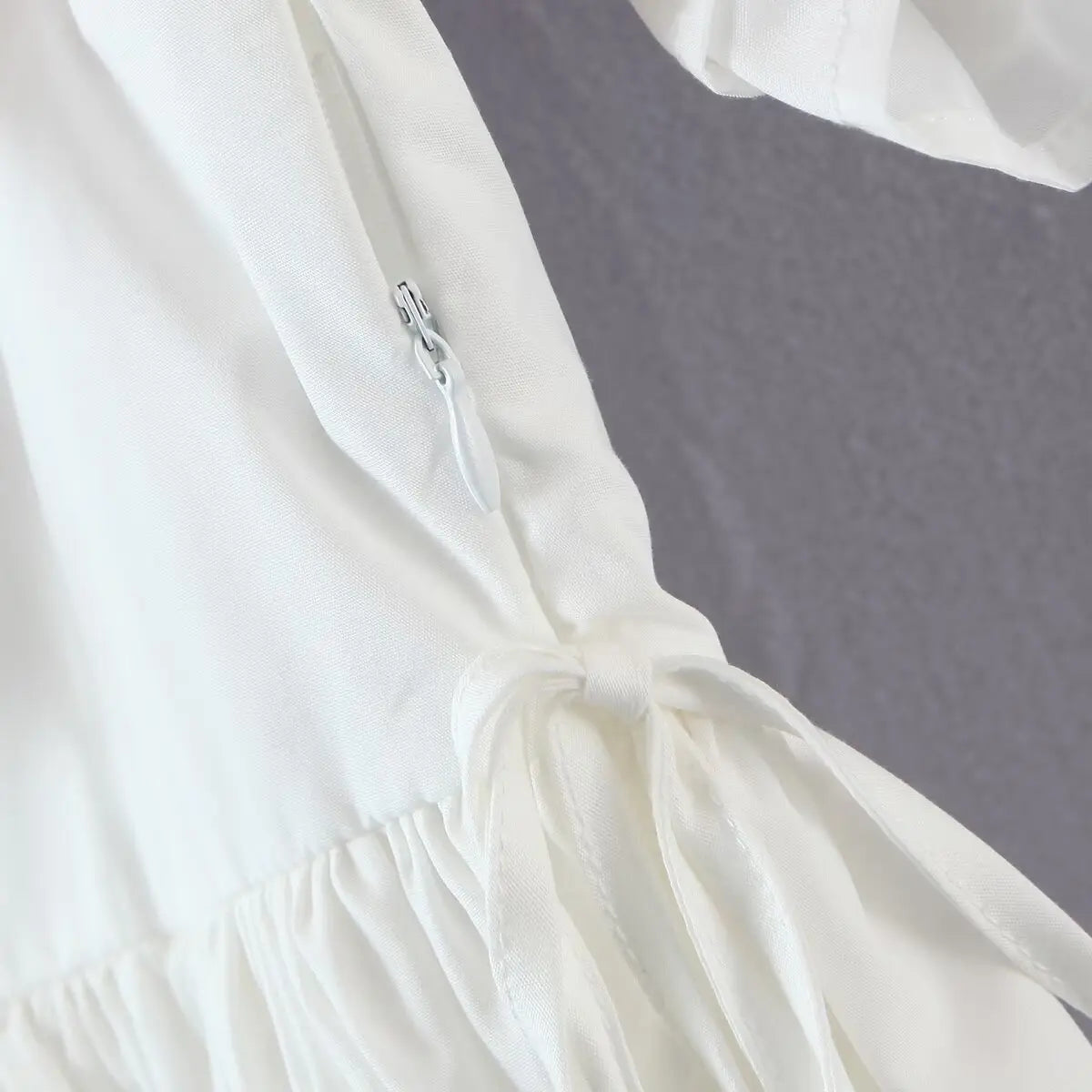 Close-up of the invisible side zipper, integrated with the waist tie detail.