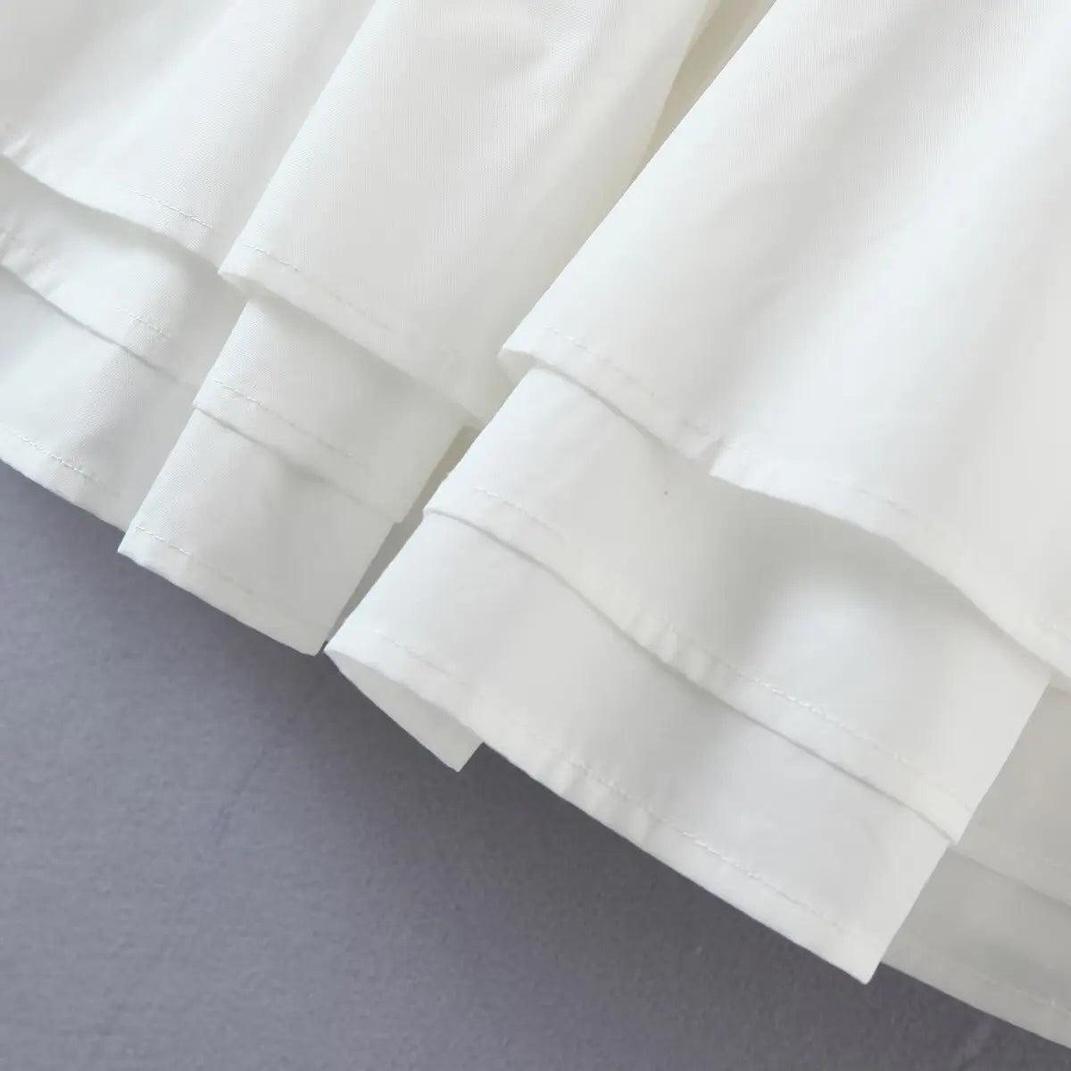 Close-up of the tiered skirt hem, showing the double-layer construction and clean stitching.