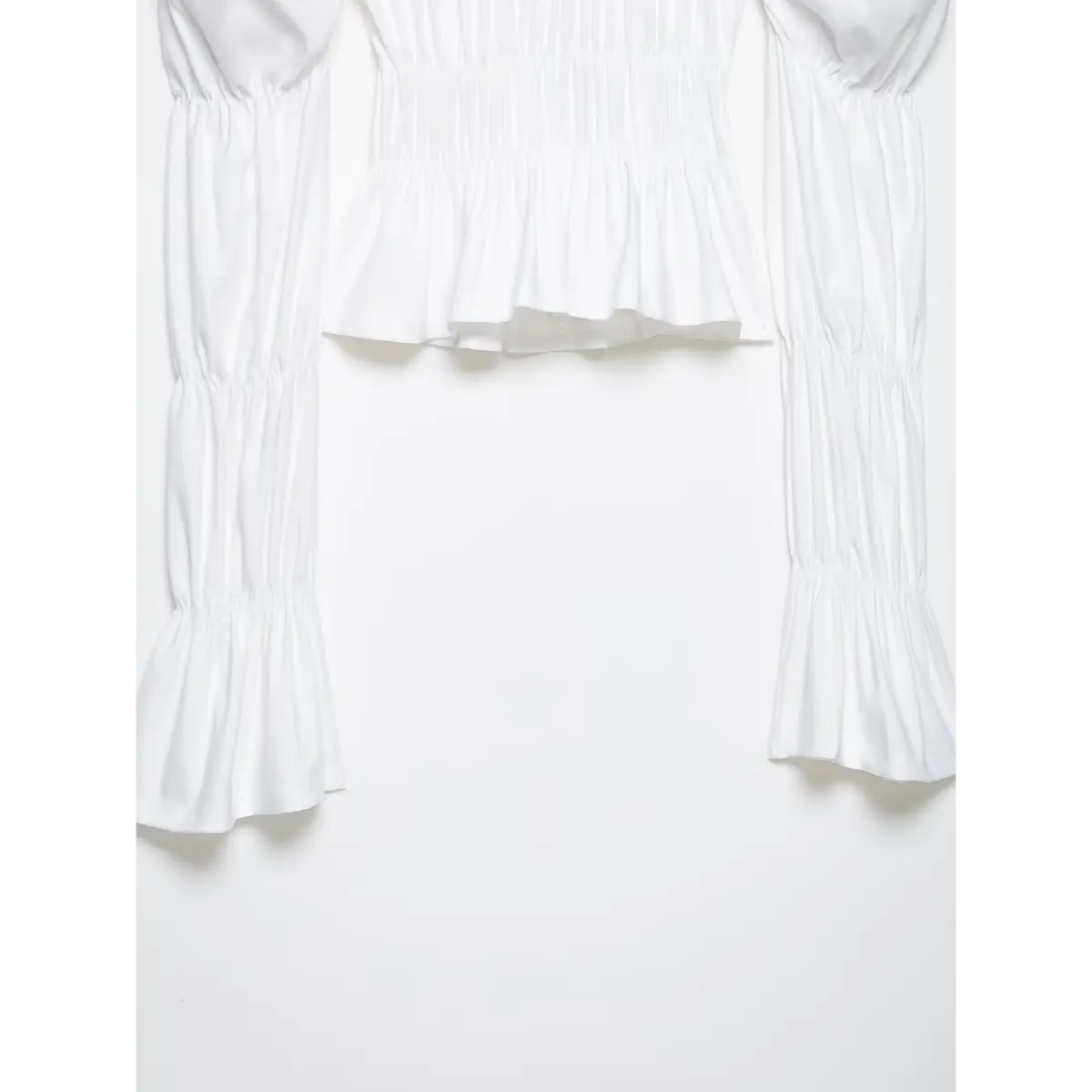 Full shot of the white top, displaying the square neckline, smocked bodice, and tiered bell sleeves.