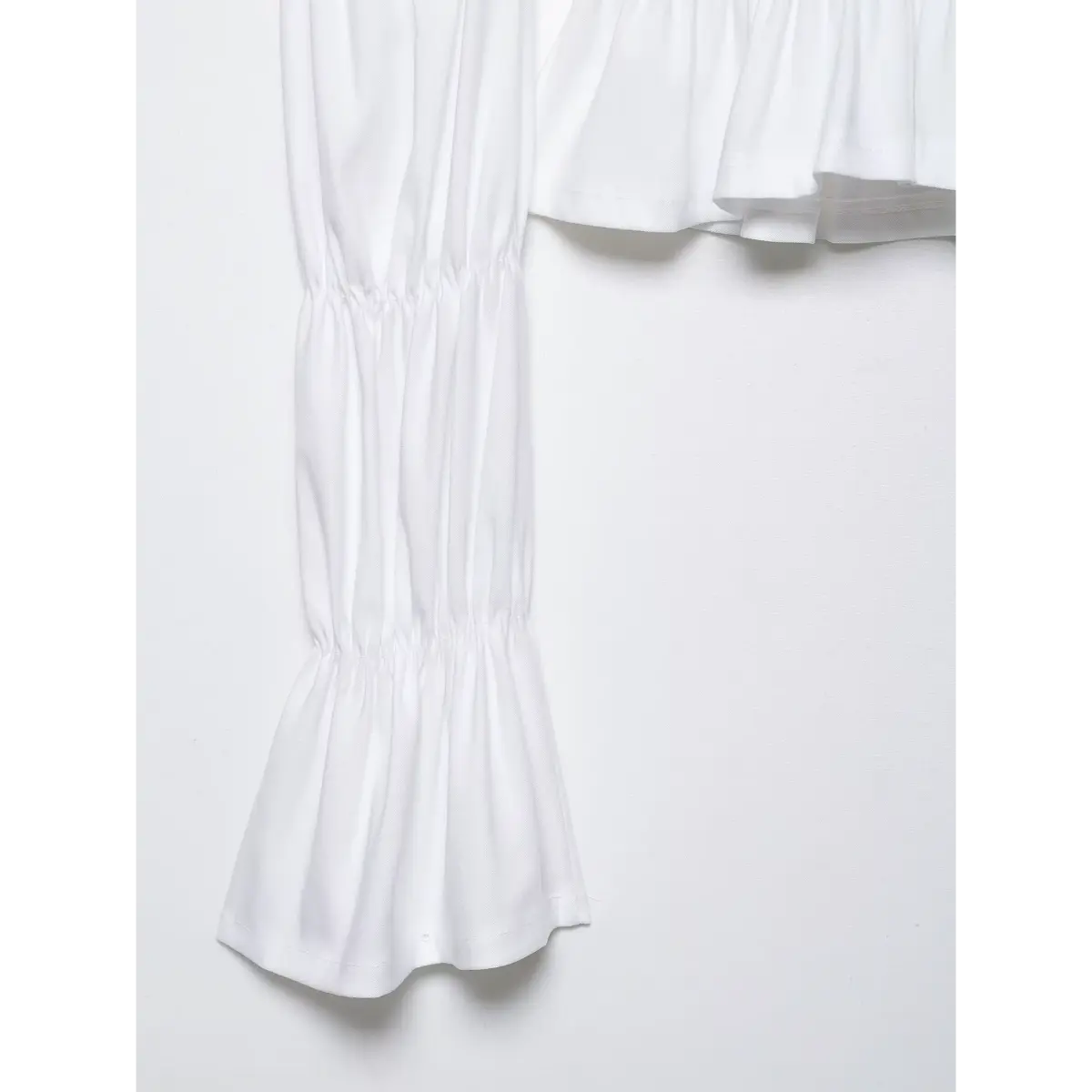 Close-up of the tiered bell sleeve, showcasing the gathered cuffs and flared hem.