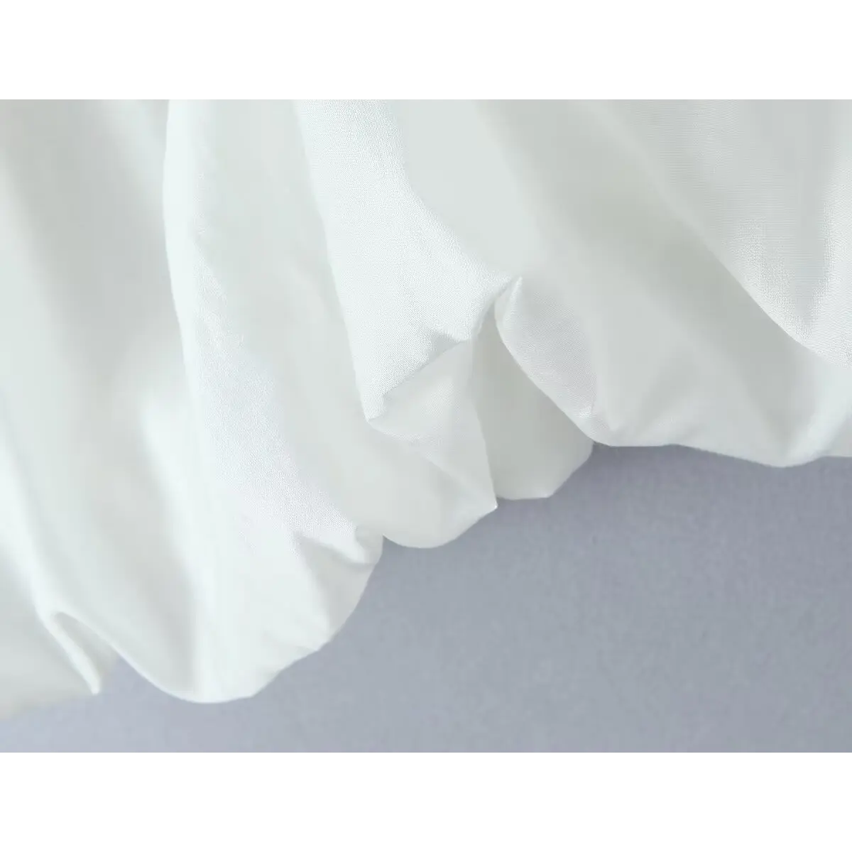  Close-up of the bubble hem, showcasing the lightweight fabric and its soft, structured drape.