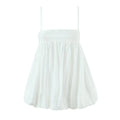  Flat lay view of the dress, featuring a smocked bodice, adjustable straps, and voluminous bubble hem.
