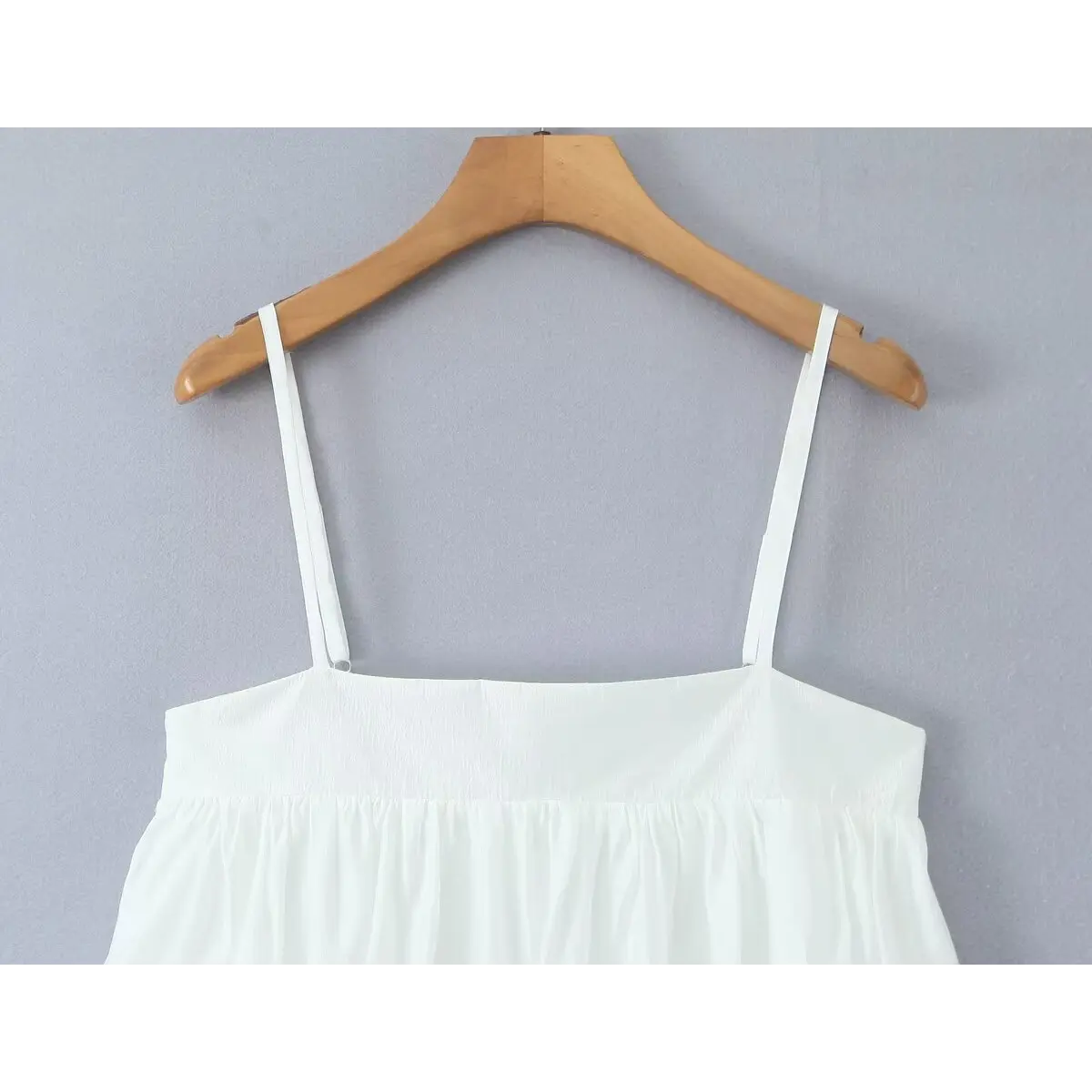 Close-up of the square neckline and adjustable spaghetti straps, showing the clean topstitching.
