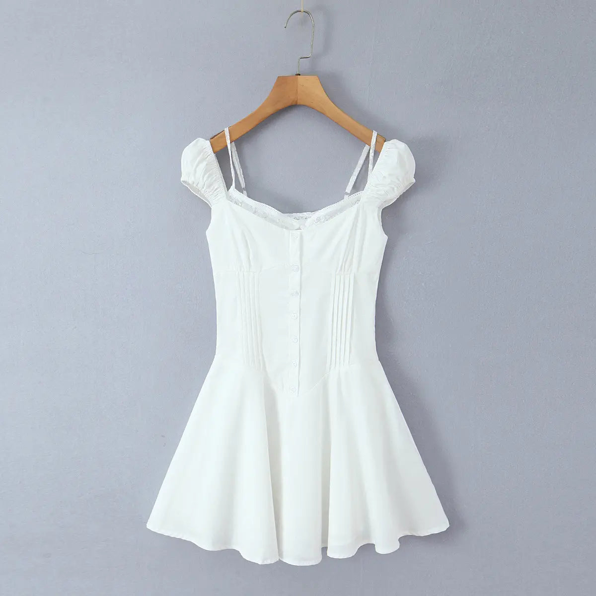 Full front view of the white puff-sleeve mini dress on a wooden hanger, showing sweetheart neckline and front buttons
