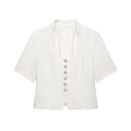 Flat‑lay front view of white textured cropped short sleeve jacket, u‑neck, decorative silver spiral buttons, front patch pockets, white background