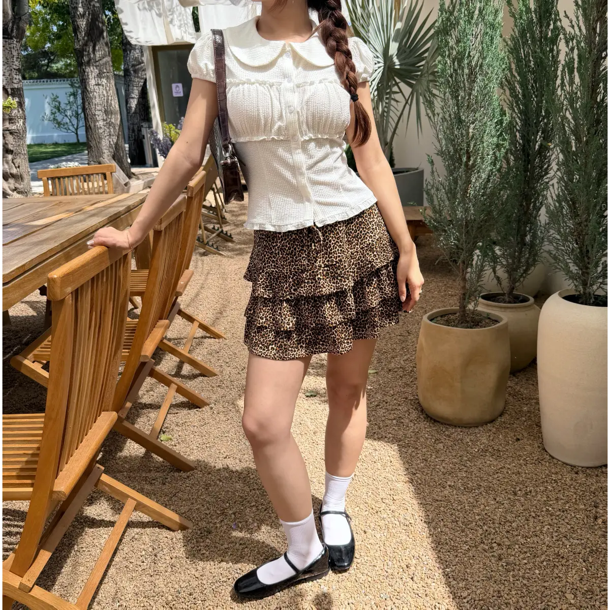 The entire outfit styled outdoors, showcasing the top, skirt, bag, and shoes in a casual setting.
