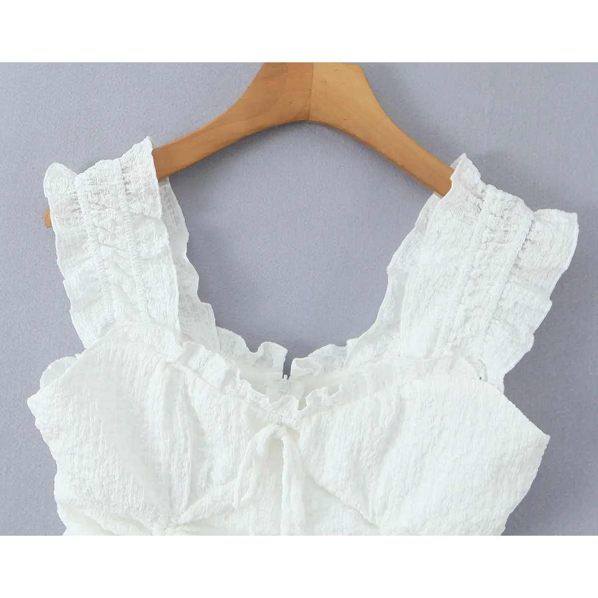 Front studio shot of the white textured dress, showing the square neckline and drawstring detail.