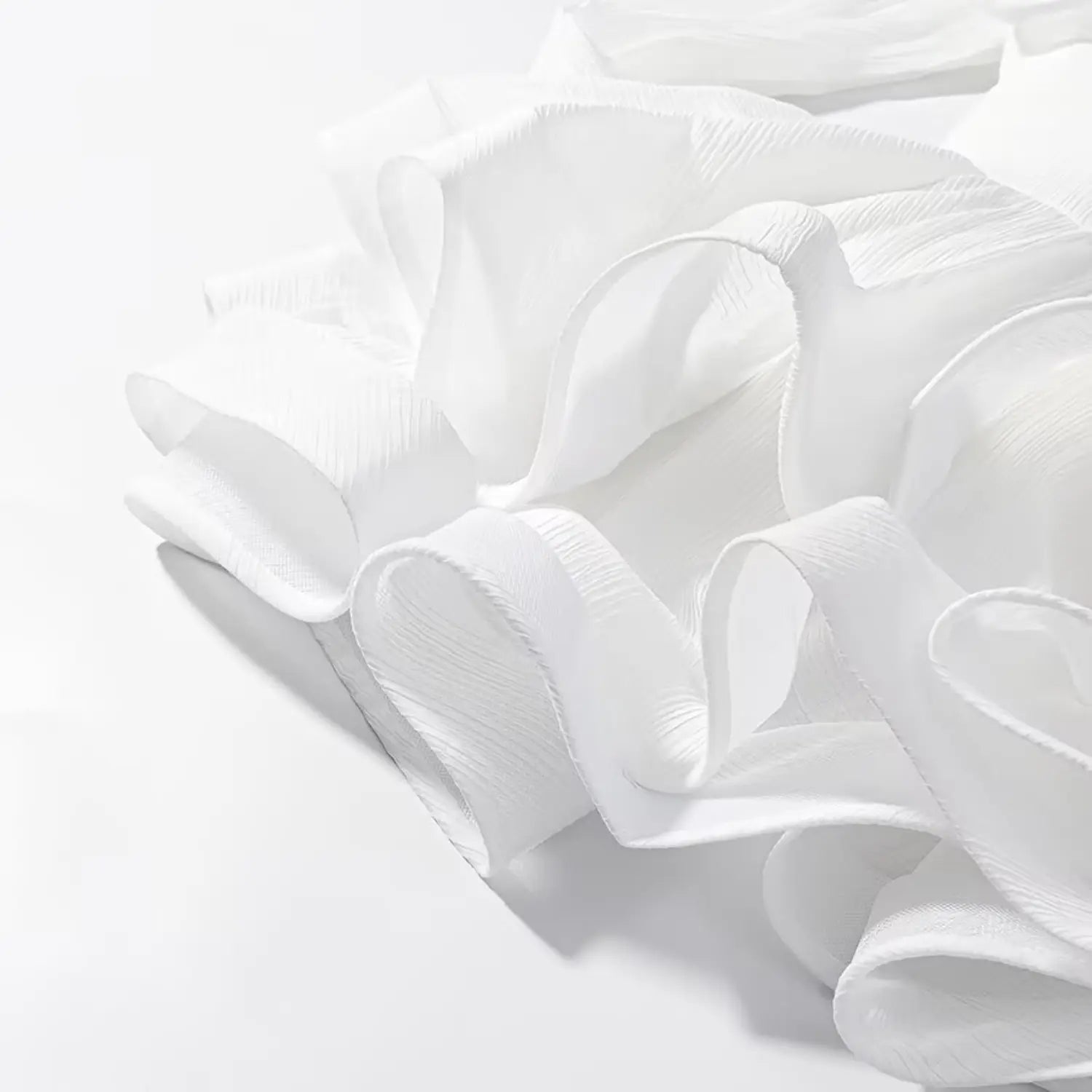 Close-up shot of layered white ruffle hem with crinkled textured fabric for mini dress