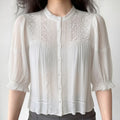 Front lifestyle shot on model of white boho vintage blouse, lace embroidery panels, 3/4 bubble ruffle sleeves, romantic casual outfit