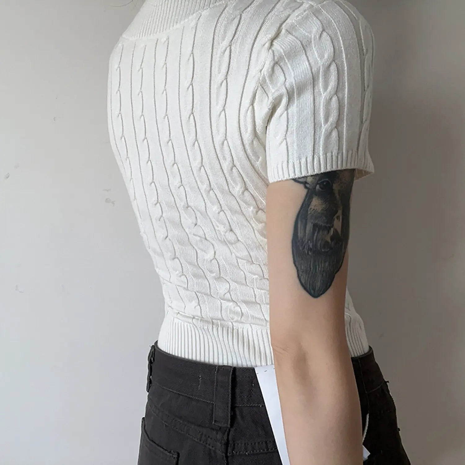 Model wearing white cable knit short sleeve knit top back view showing knit texture