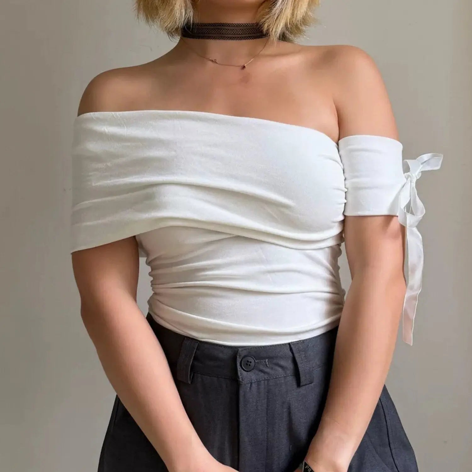 Solid white off-the-shoulder fitted top with side ruched design and separate tie bow sleeve, front lifestyle photo