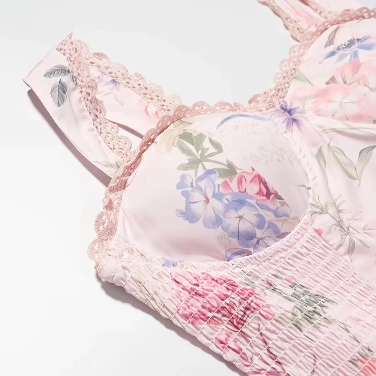 Shoulder strap close-up, wide fabric strap trimmed with scalloped floral lace, allover small watercolor blossom print