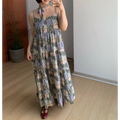 Full spread front indoor mirror shot of ultra-loose multi-tier ruffle cami maxi sundress, retro collage castle & crescent moon print, matching self-fabric neck tie choker, thin adjustable spaghetti straps, extra flowy floor-length tiered skirt, burgundy strap flat shoes, plain white wall & light wood flooring backdrop