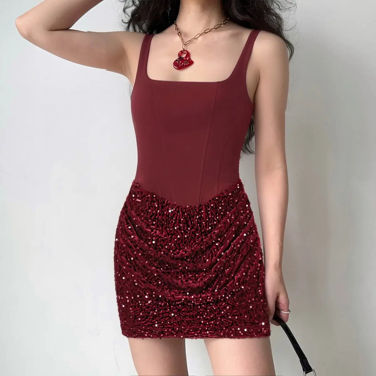 Model wearing a wine red corset sequin mini dress, showcasing the square neckline, fitted bodice, and gathered sequin skirt.