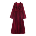 Front view of wine red long sleeve maxi dress with deep V-neck, ruffle details, waist ruffle and pleated flared skirt