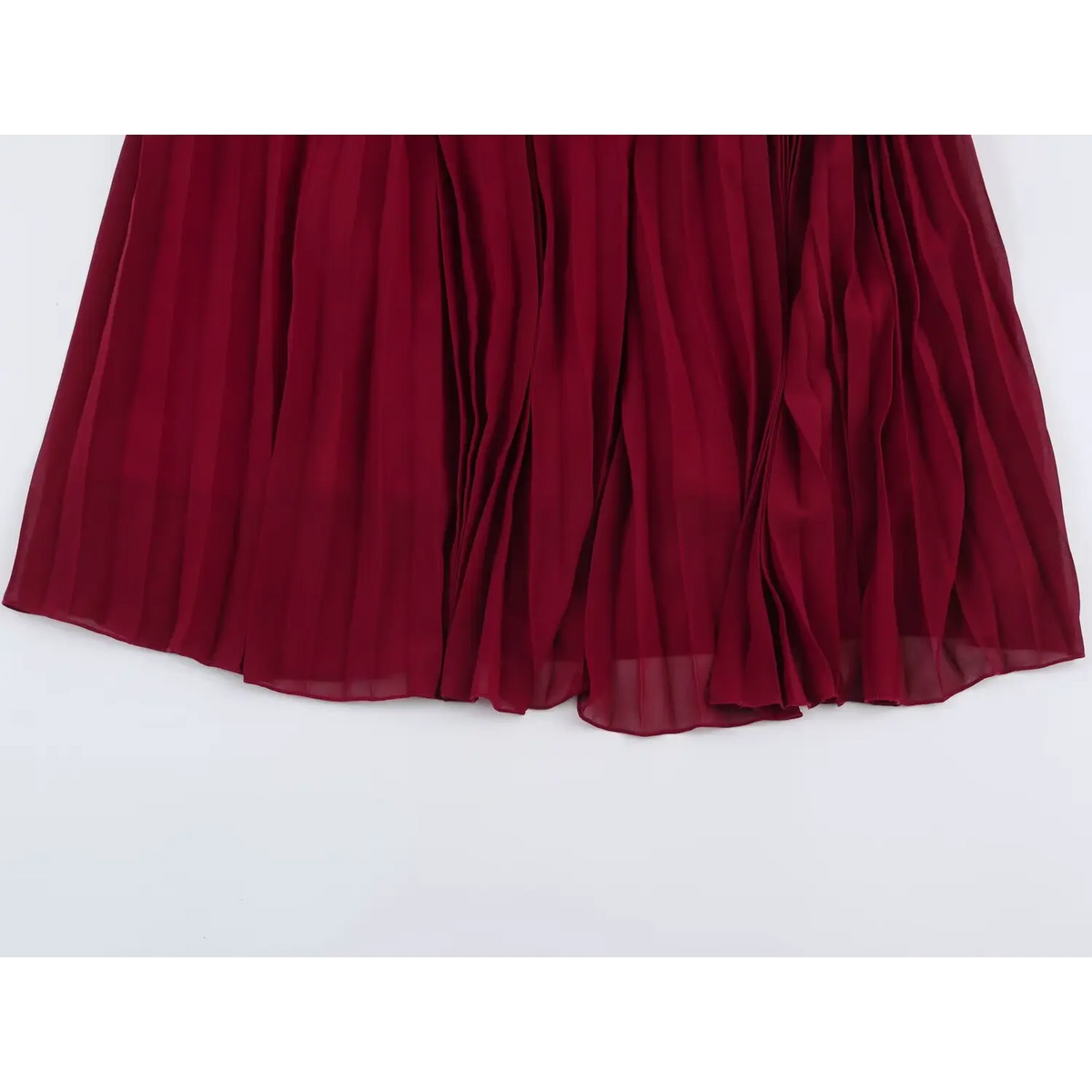 Close-up of pleated chiffon skirt fabric of wine red maxi dress with dense vertical pleats