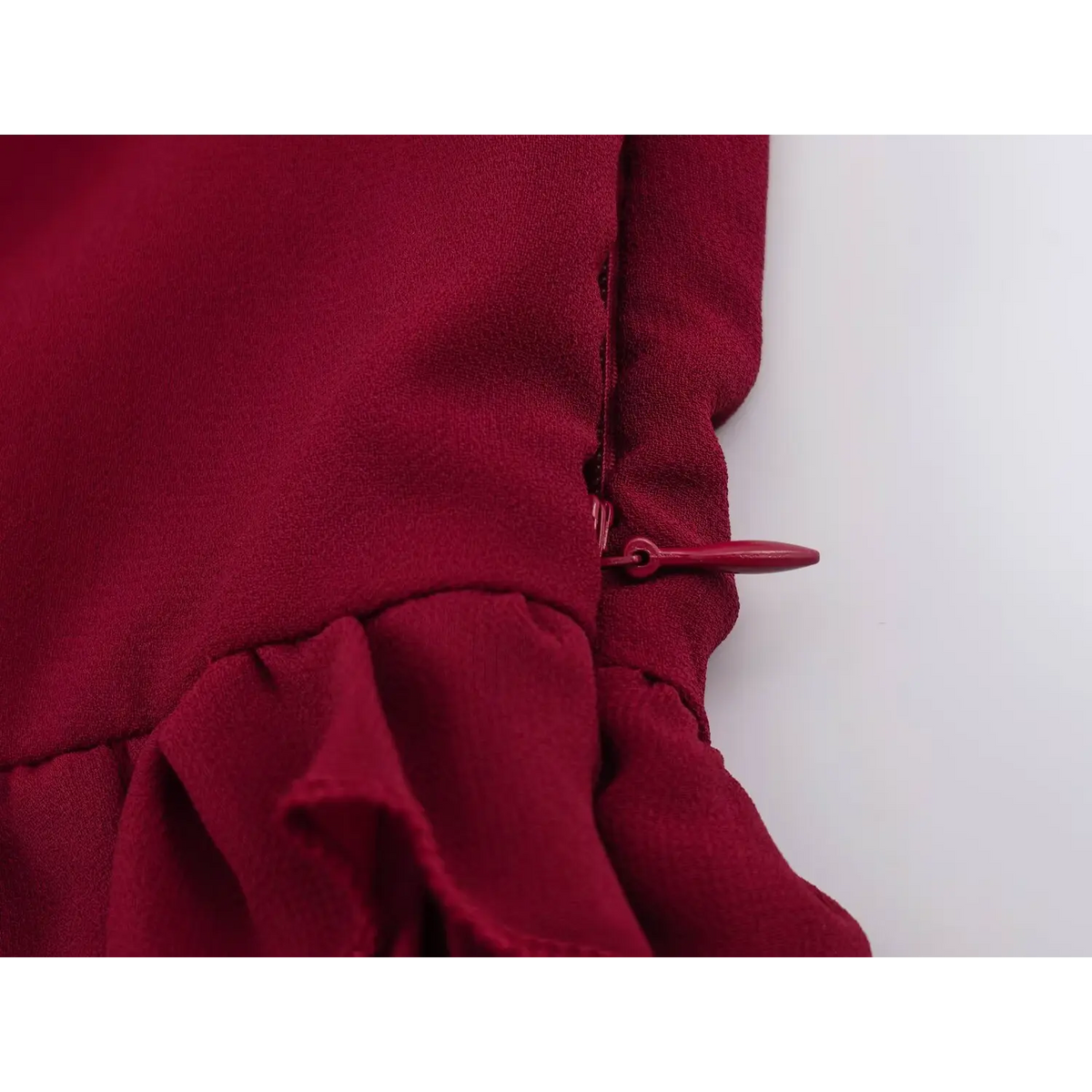 Close-up of concealed side zipper in matching wine red on the maxi dress