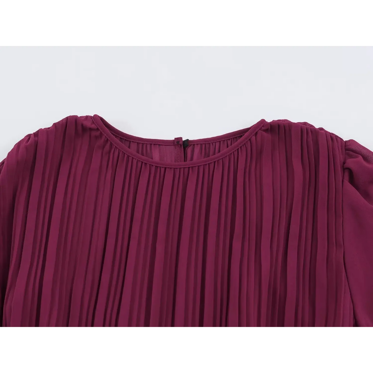 Close-up of round neckline and shoulder of wine red pleated maxi dress with fine vertical pleats