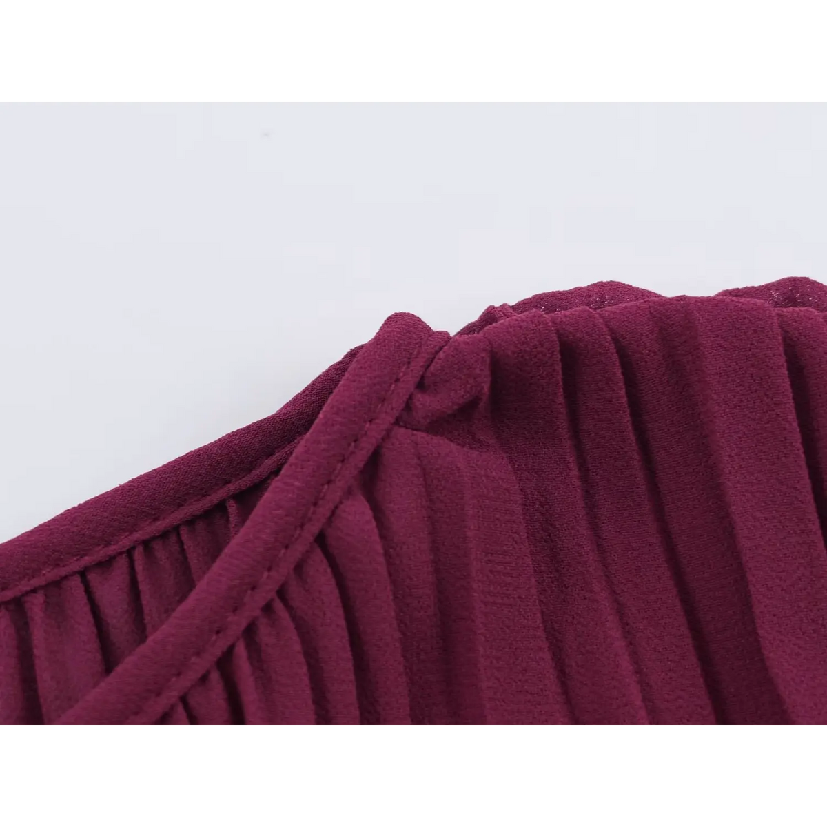 Close-up of wine red pleated fabric with neat seam stitching