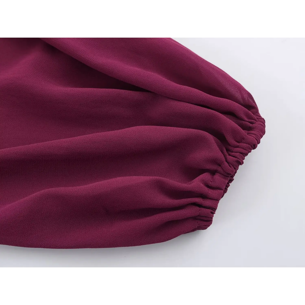 Close-up of wine red chiffon fabric with gathered edge detail