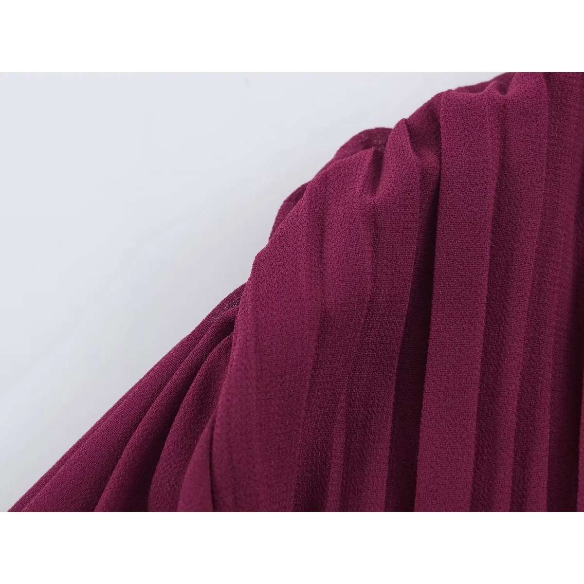Close-up of deep wine red fabric with fine vertical pleated texture