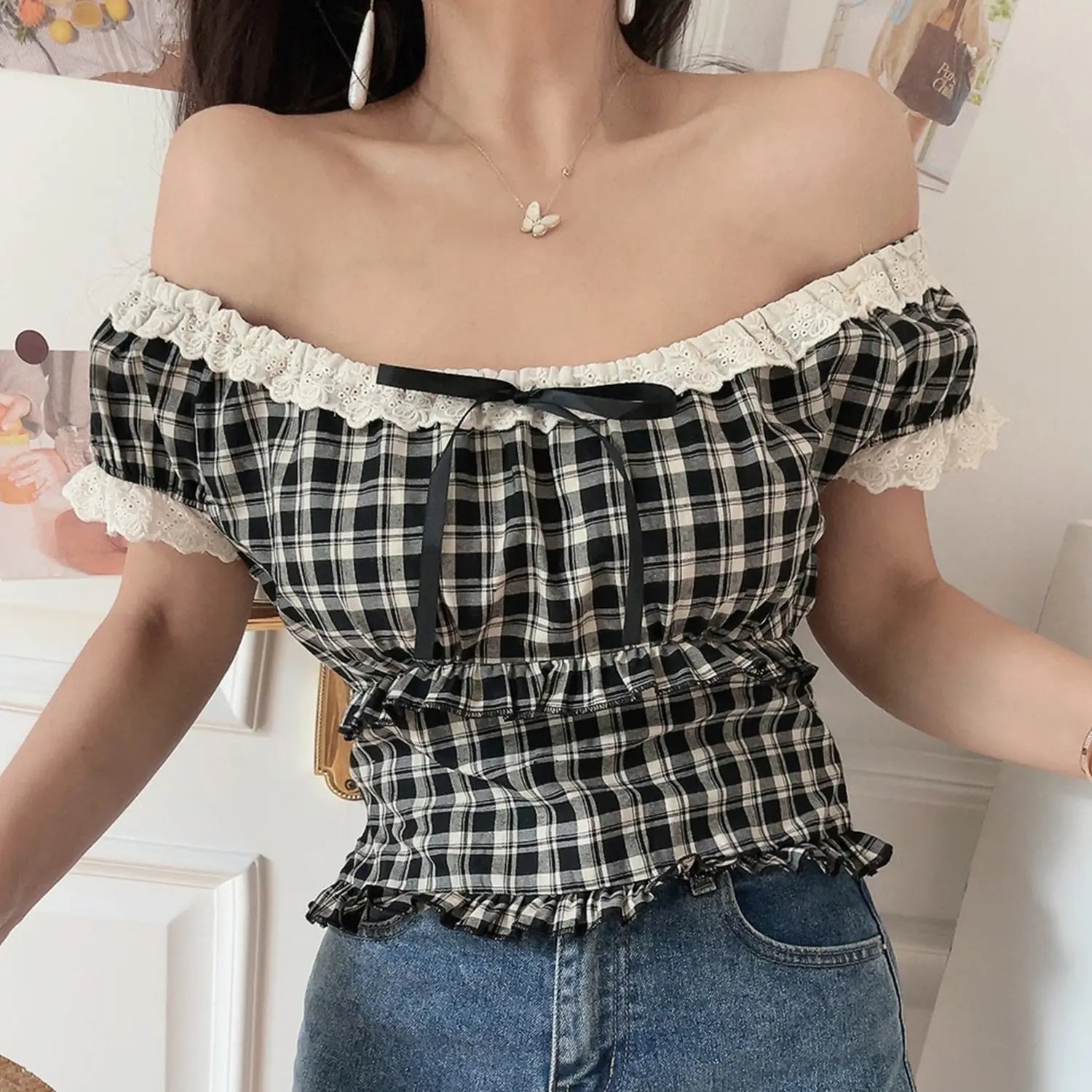 Women black white plaid lace off shoulder crop top, puff sleeve ribbon ruffle hem, indoor model shot with denim jeans