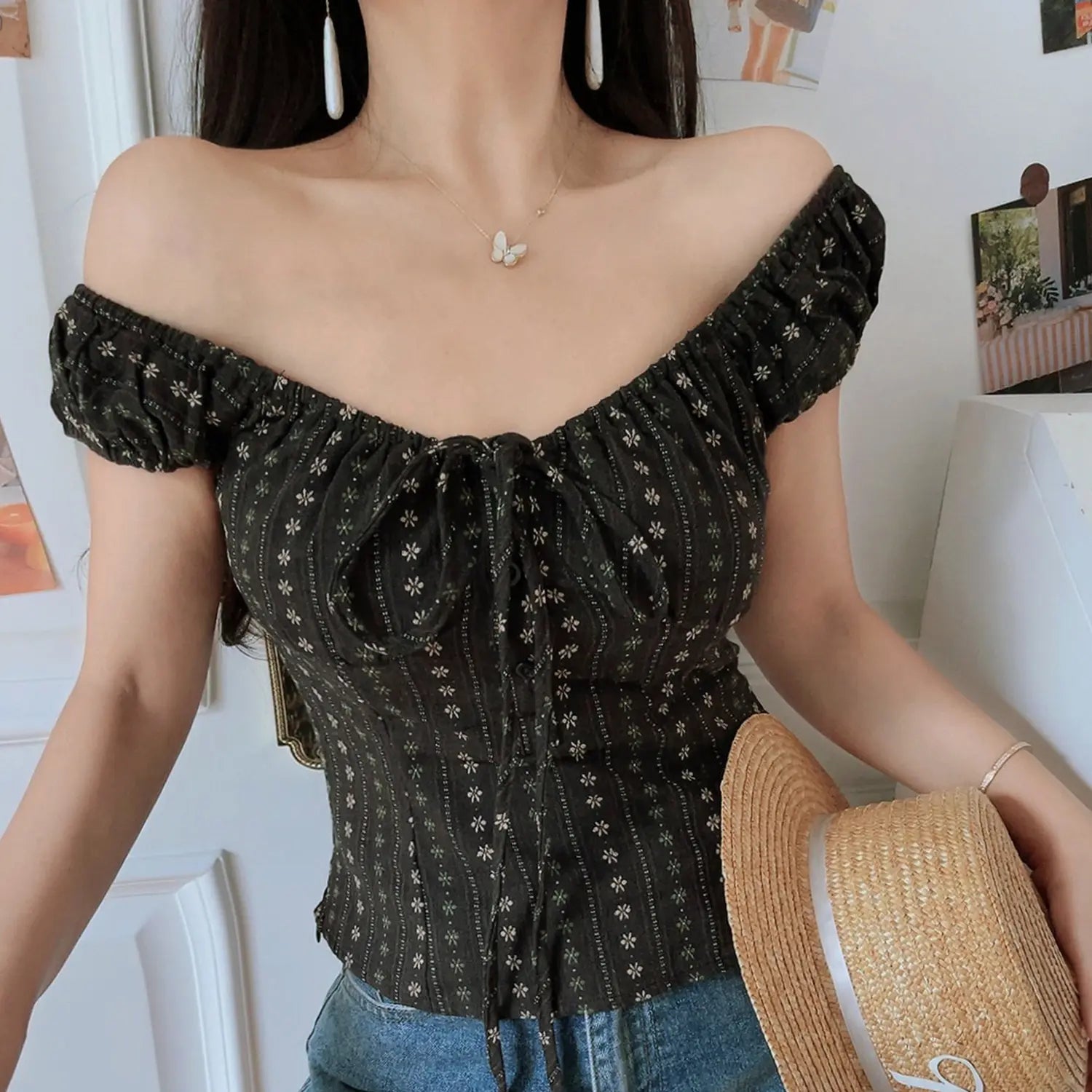 Women dark brown vertical floral off shoulder crop top, puff sleeve front tie fitted waist, indoor half body model shot with straw hat