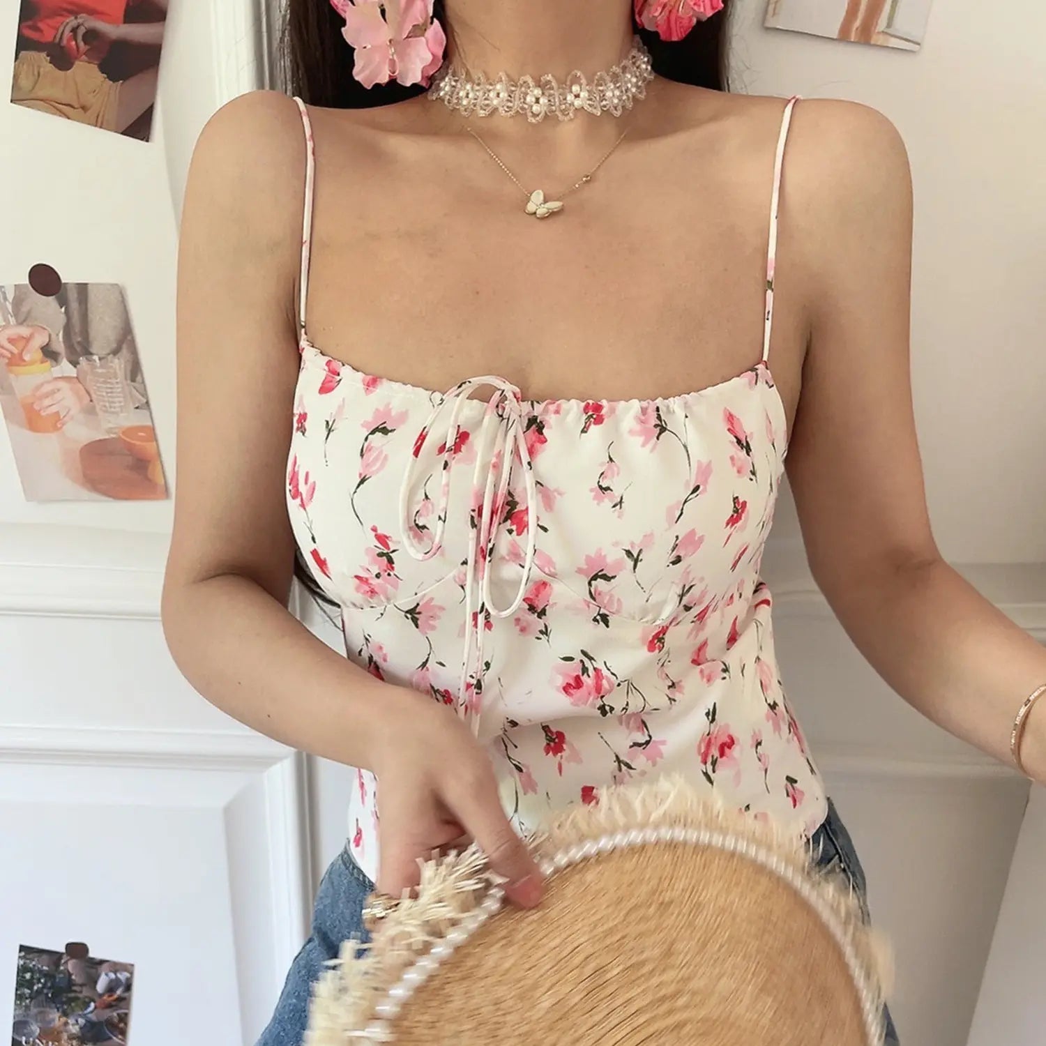 Women white pink floral drawstring fitted cami, elastic square neck adjustable front tie, half body indoor model shot holding pearl frayed straw bag