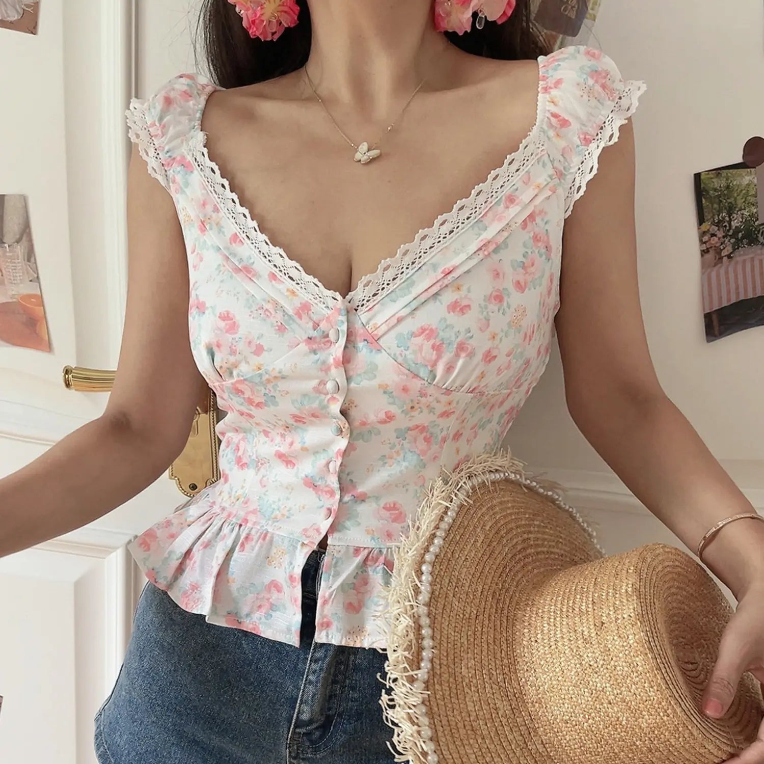 Women white pink floral lace v-neck fitted crop top, frayed pearl straw hat beside body, indoor partial model shot