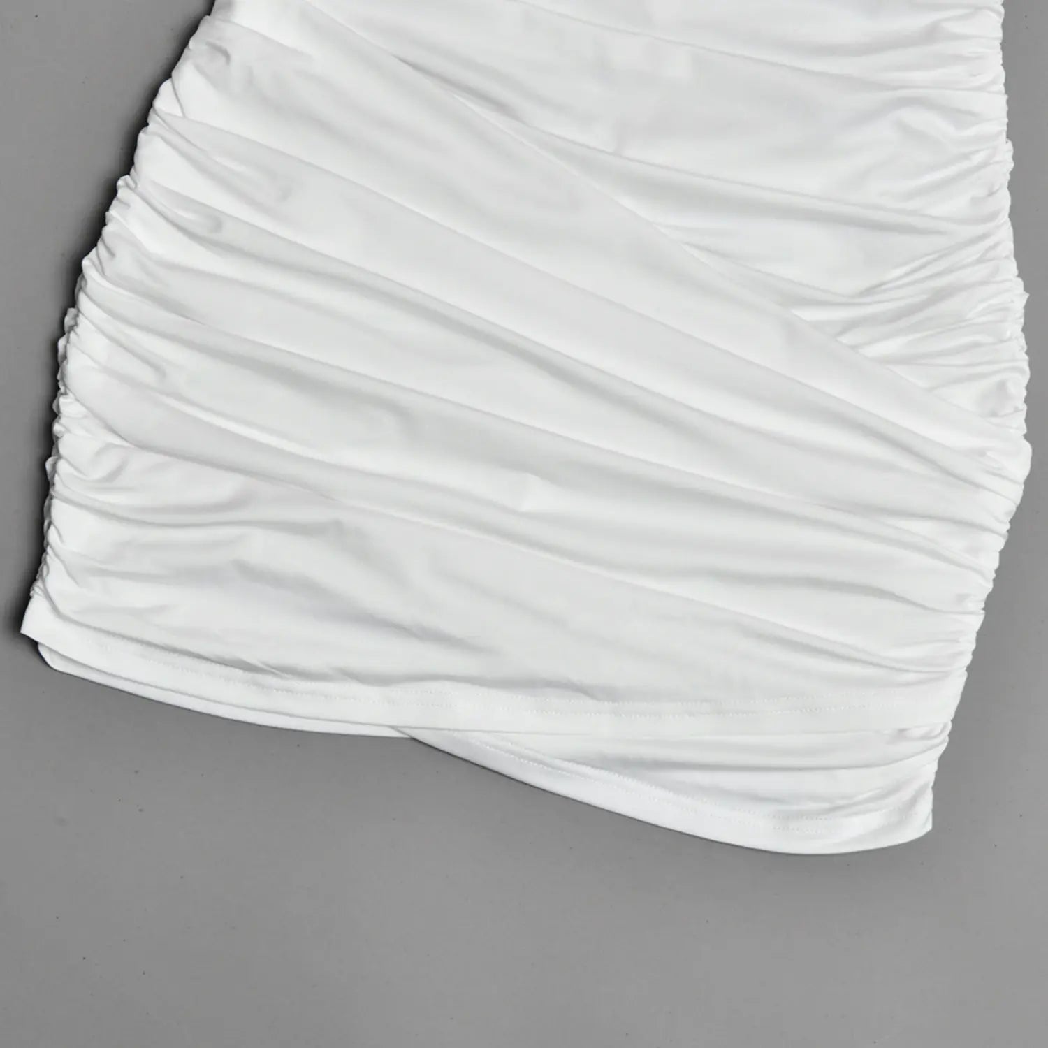 Close-up wrap overlay ruched hem skirt of white bodycon mini dress