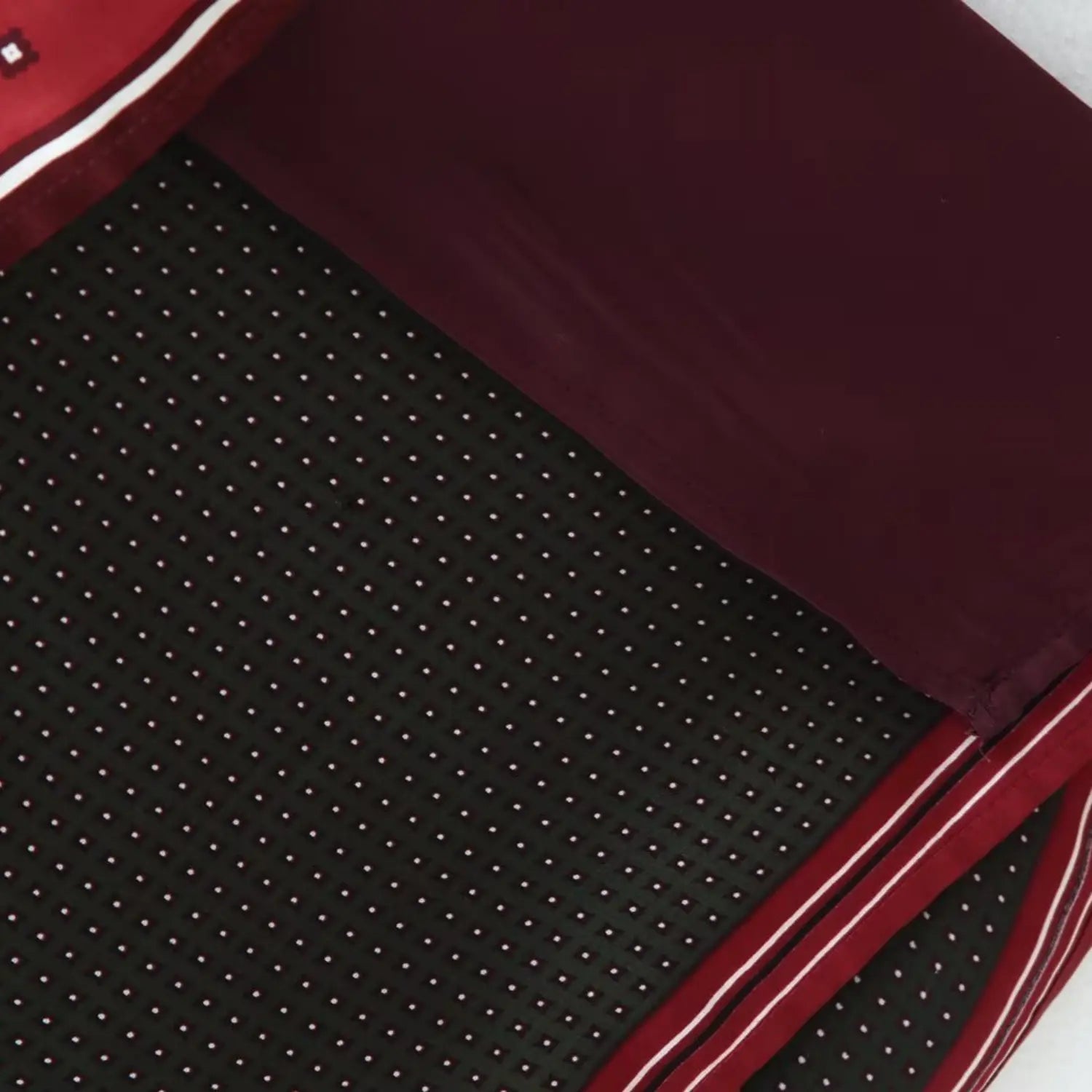 Lower hem shot of solid burgundy inner lining beneath outer printed wrap panels