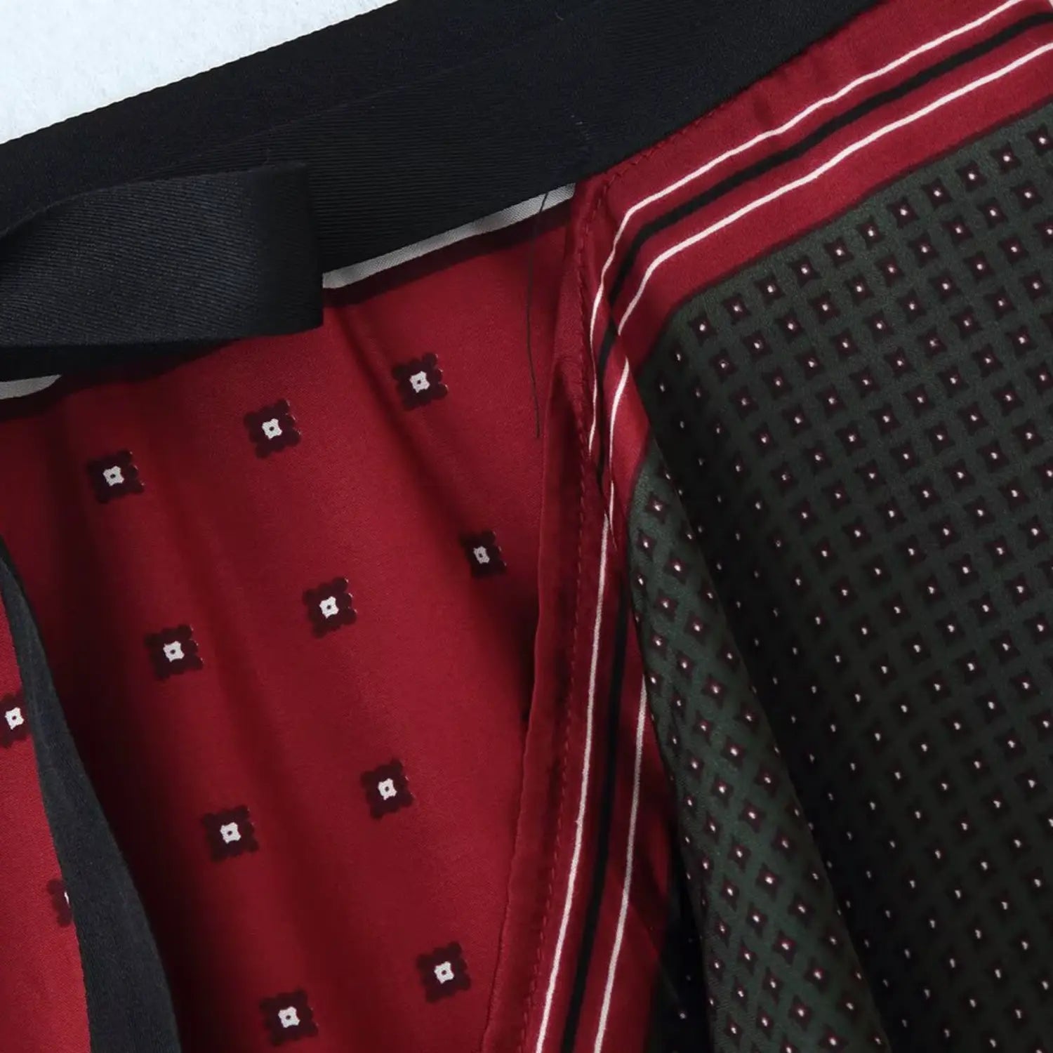 Detail of overlapping wrap panel with double white-red contrast border piping, two-tone reversible fabric construction