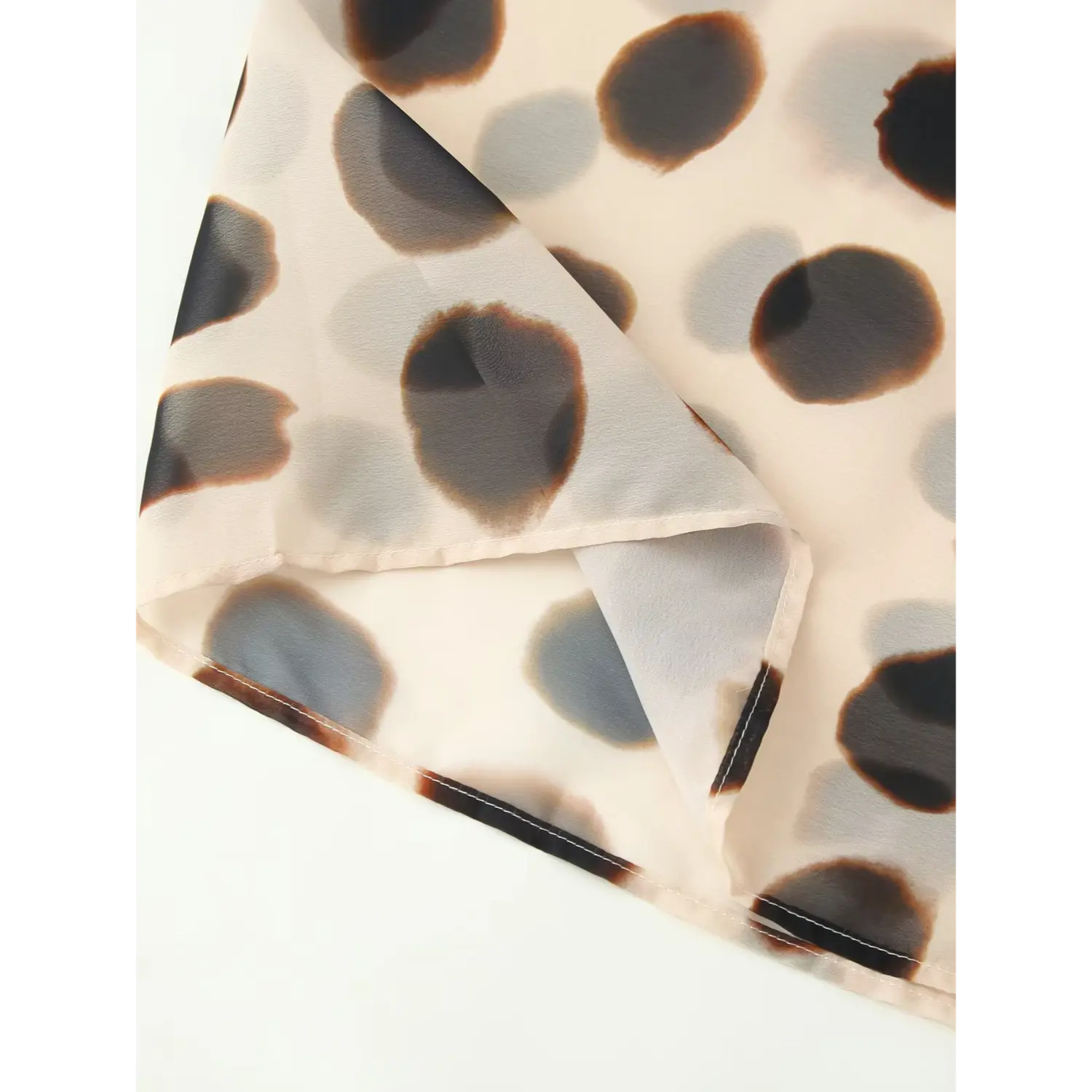 Abstract ink blot print wrap skirt hem close-up, full solid lining with neat stitched hem, lightweight summer chiffon