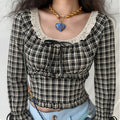 Model wearing vintage black cream check long sleeve cropped blouse, eyelet lace square neck with front satin bow, tiered ruffle waist, flare ribbon cuffs, paired with light blue jeans, sweet casual streetwear outfit