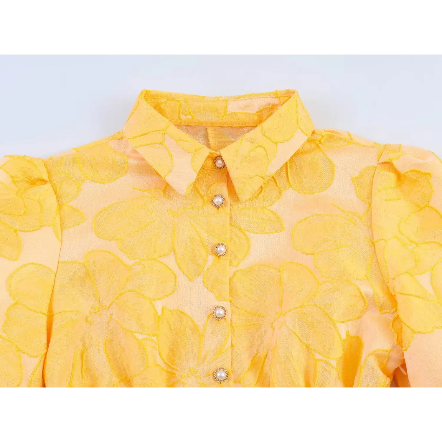 Close-up of front pearl decorative buttons, shirt lapel collar and raised floral jacquard fabric