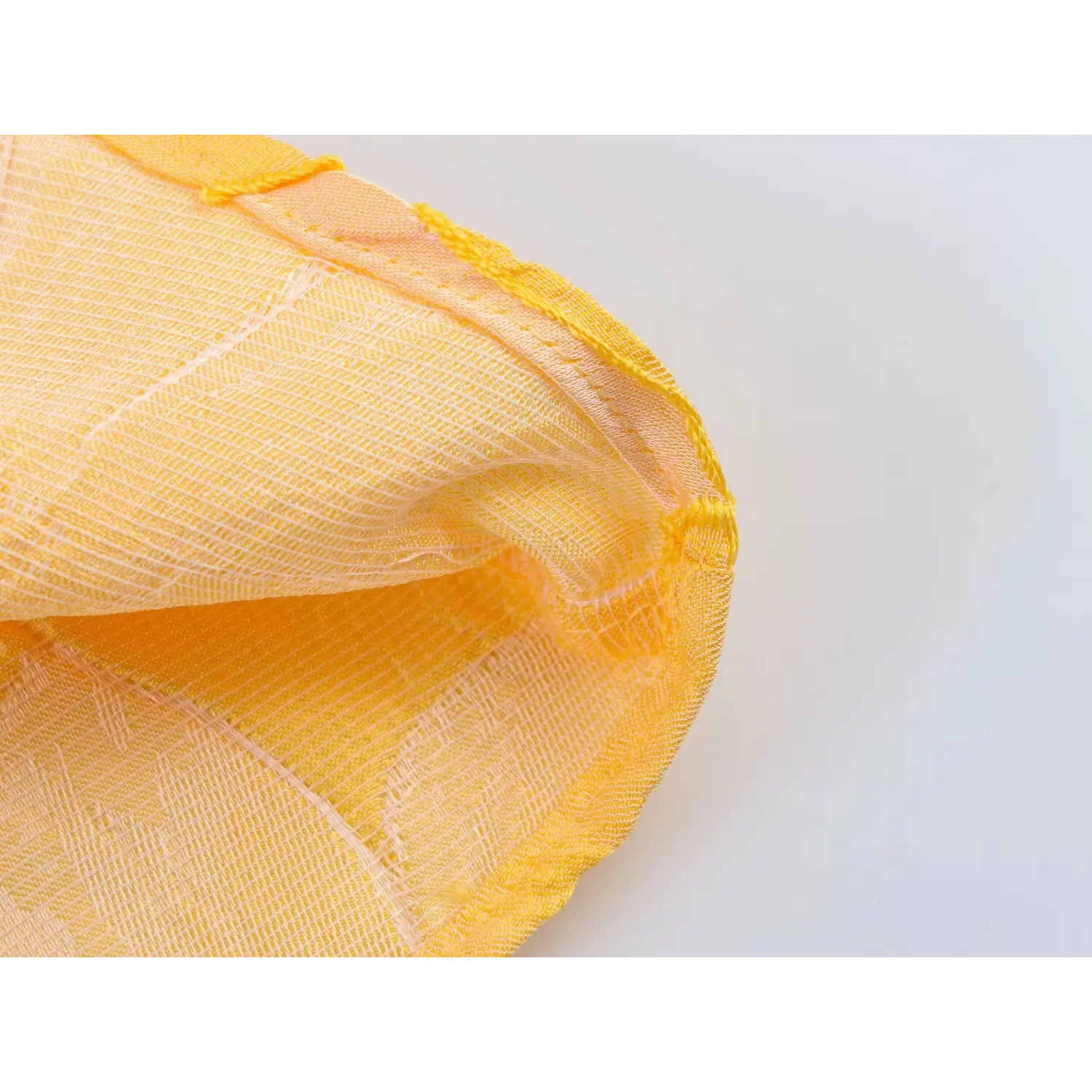 Close-up shot of the mesh inner lining and yellow overlock stitching of the textured floral dress