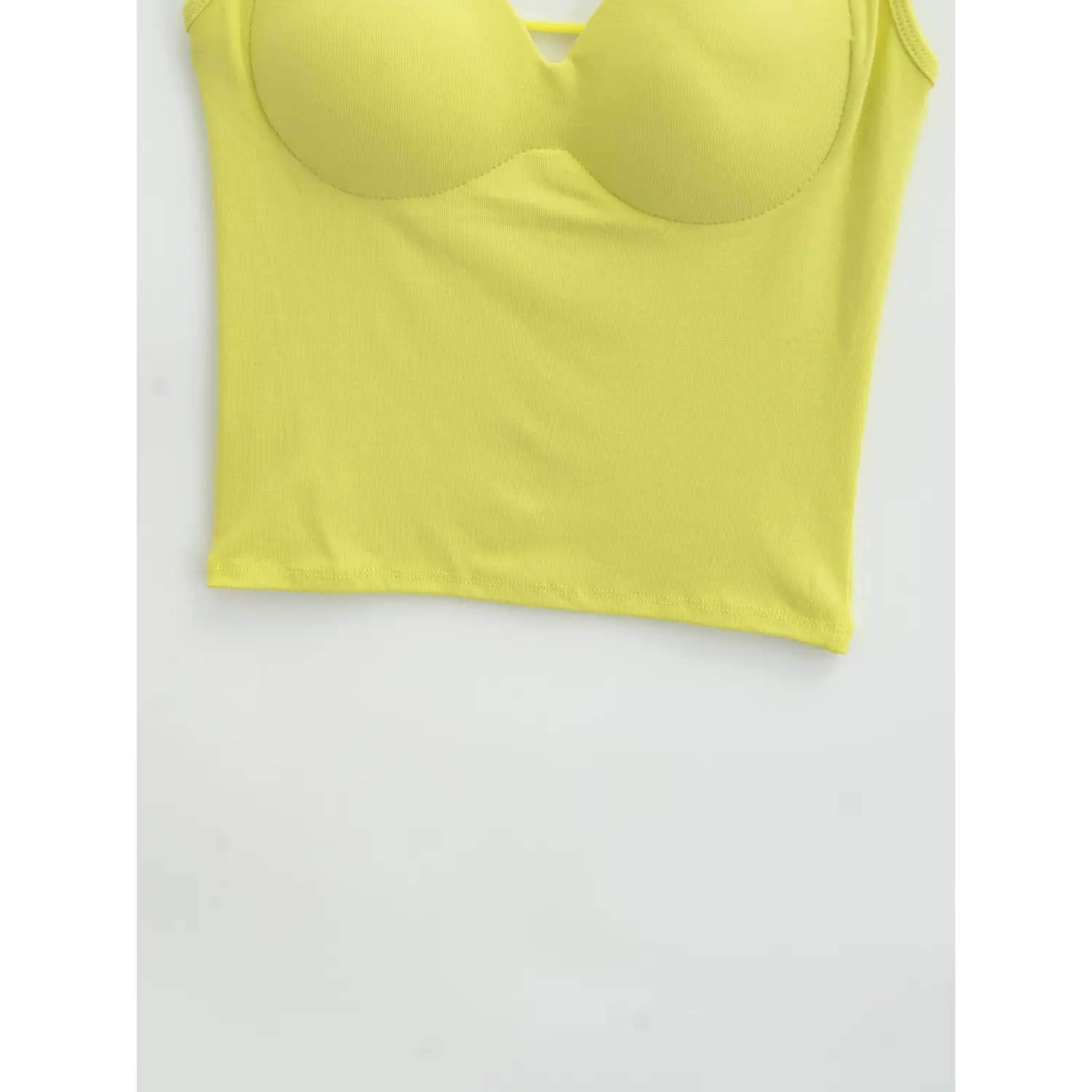 Yellow open back camisole front hem flat close-up, high stretch rib slim cut straight double line overlock cropped hem solid knit fabric white background shot