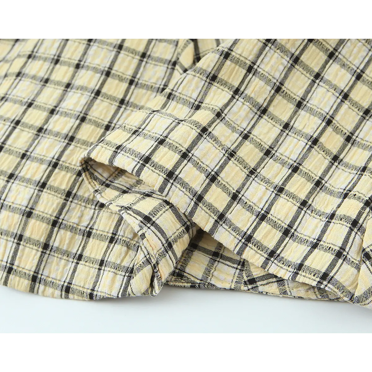 Cropped hem detail of yellow black plaid casual camisole top