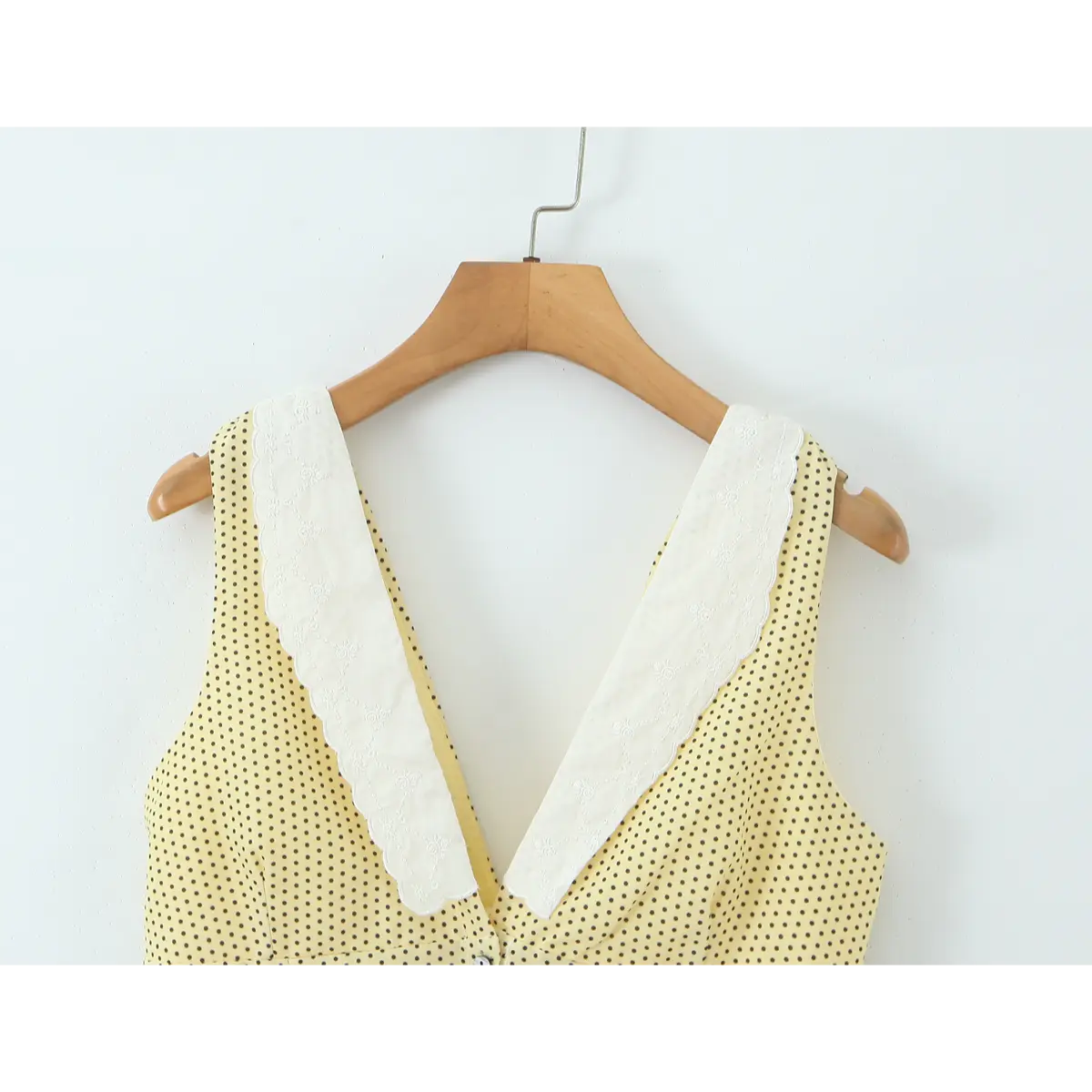 Close of embroidered lace V collar on yellow polka dot dress