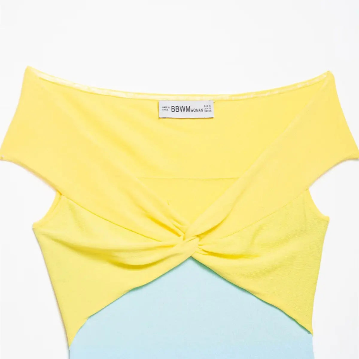 Neckline detail of the yellow and blue color-block knit top, showing the off-the-shoulder style, twisted knot, and brand label