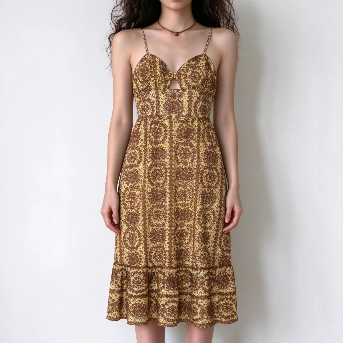 Model wearing yellow brown floral print spaghetti strap midi dress with bust cutout and ruffle hem, white background