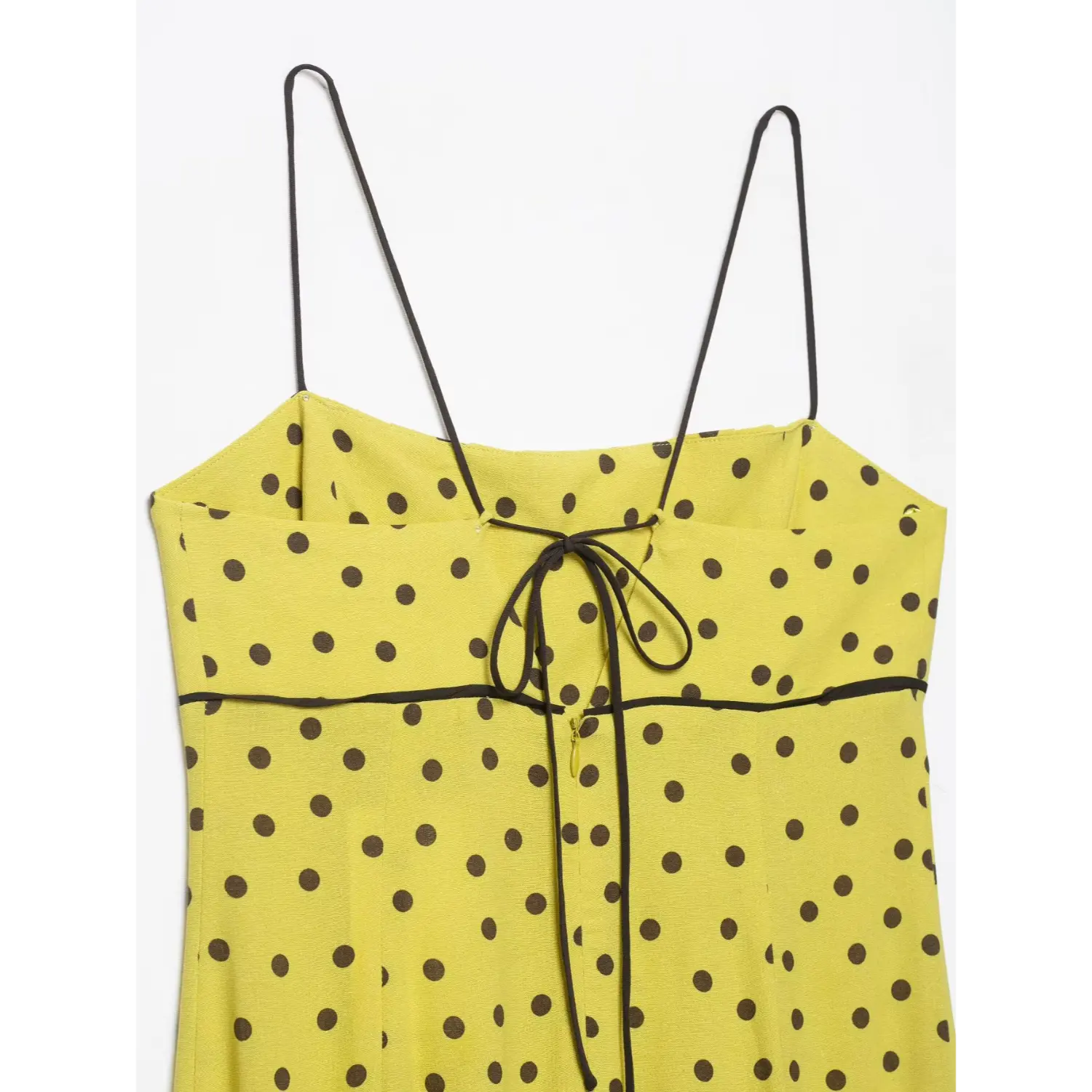 Partial back view of yellow brown polka dot spaghetti strap midi dress with waist black piping and back tie