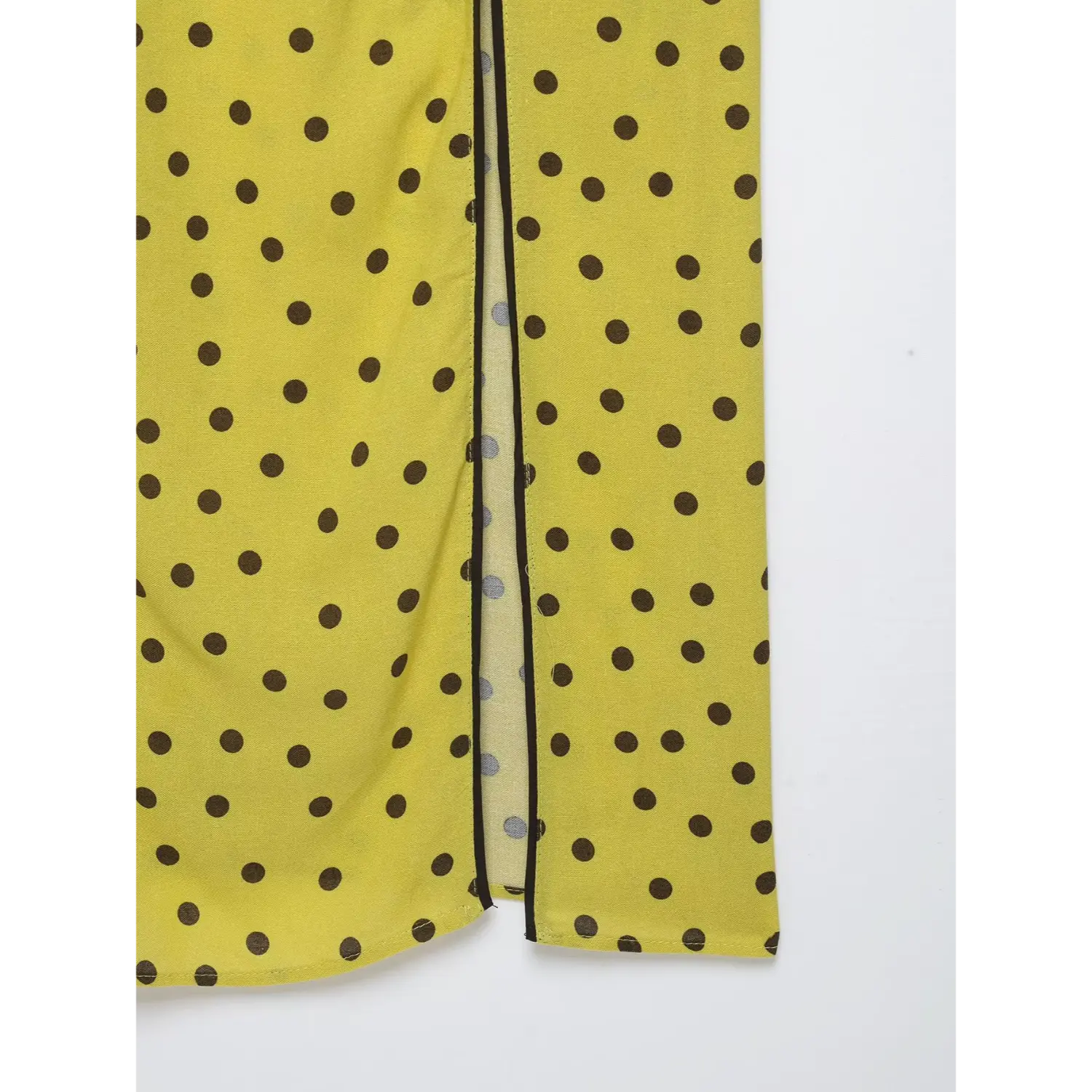 Close-up of side slit hem with black piping on yellow brown polka dot spaghetti strap midi dress