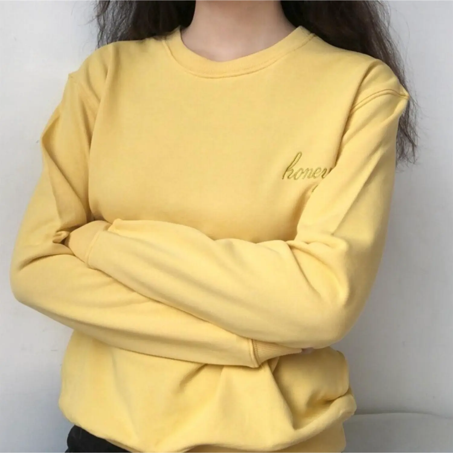 Model crossed arms pose casual yellow honey embroidered long sleeve crew neck sweatshirt